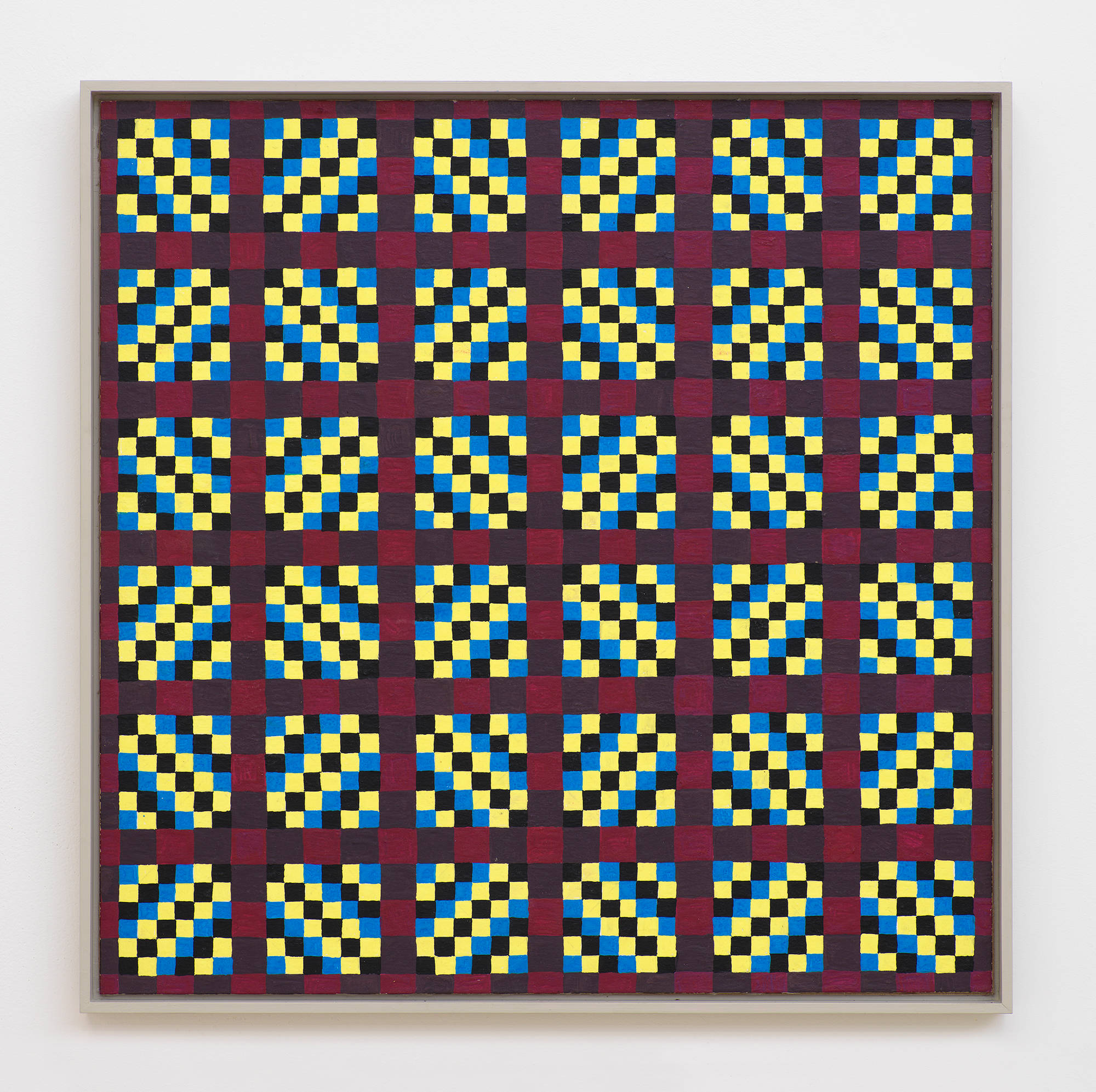 On a white wall a square painting depicting a grid of crisscrossing lines generating many rectangles, and triangles. The dominant colors are hues of maroon, black, blue, and yellow. The frame is painted gray.