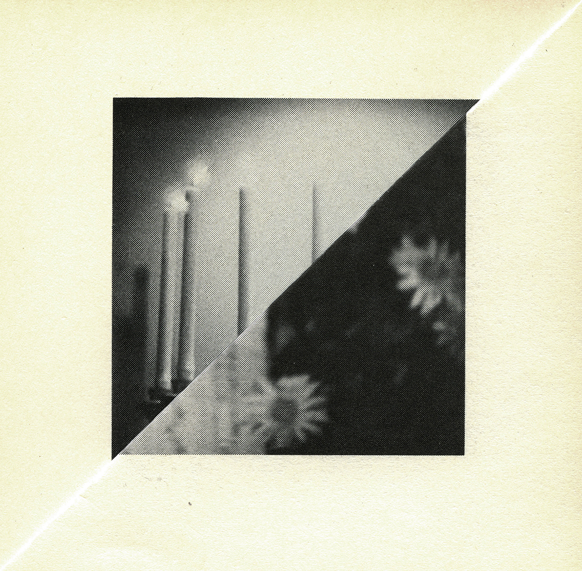 Image of the folded corner of the yellowed page of a book with a a central black and white square of imagery made of two triangles, showing candles and daisy flowers, which is the result of the folding of the page, and the internal images on the facing book pages.