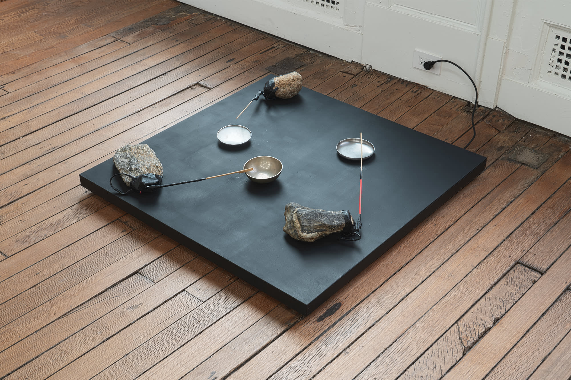 Tom Thayer, Rock Symphony, 2024, Assembled from domestic objects from artist’s home– stones, metal lid, bowls, wood, mixed media, and electronics, 36 × 36 × 5 ½ in. (91.44 × 91.44 × 13.97 cm)