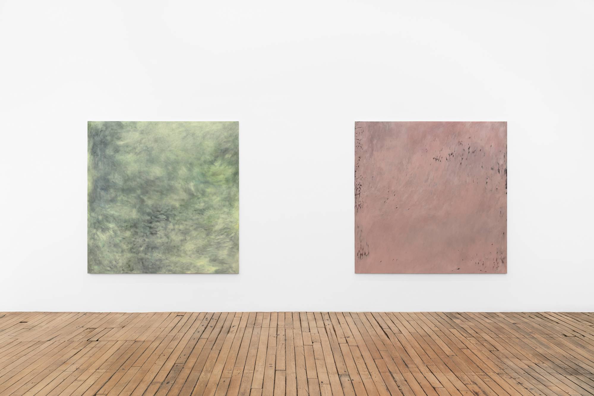 Two large square abstract paintings installed close to each other on a long gallery wall.