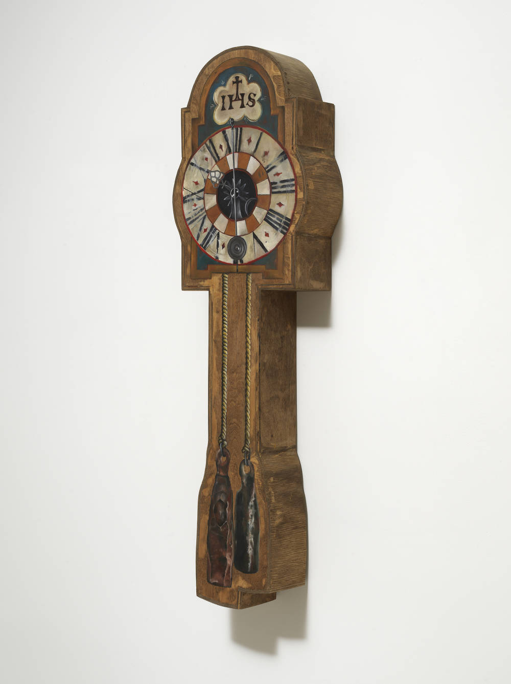 Image of an artwork by Libby Rothfeld of a shaped wooden panel with a very realistically rendered clock painted on the surface. This clock looks like a traditional coo coo clock with weights dangling down on ropes from the clock's face. 