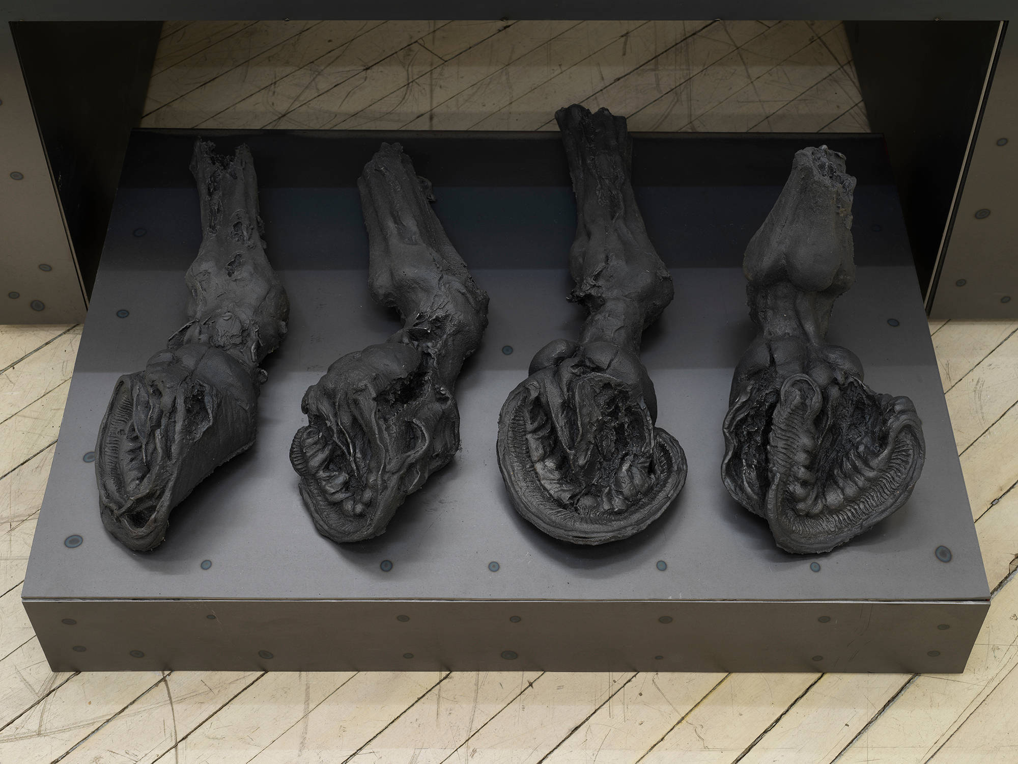 Four cast iron horse hooves resting on top of an iron base.