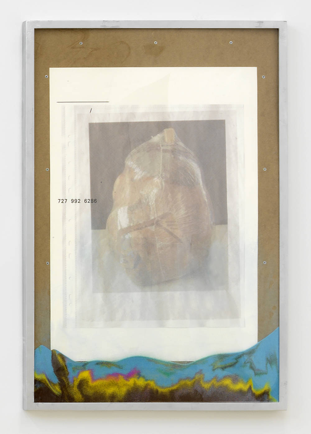 In a silver frame, an abstract poster image with a brown border. At the bottom of the frame behind glass is a pile of differently colored sand. 