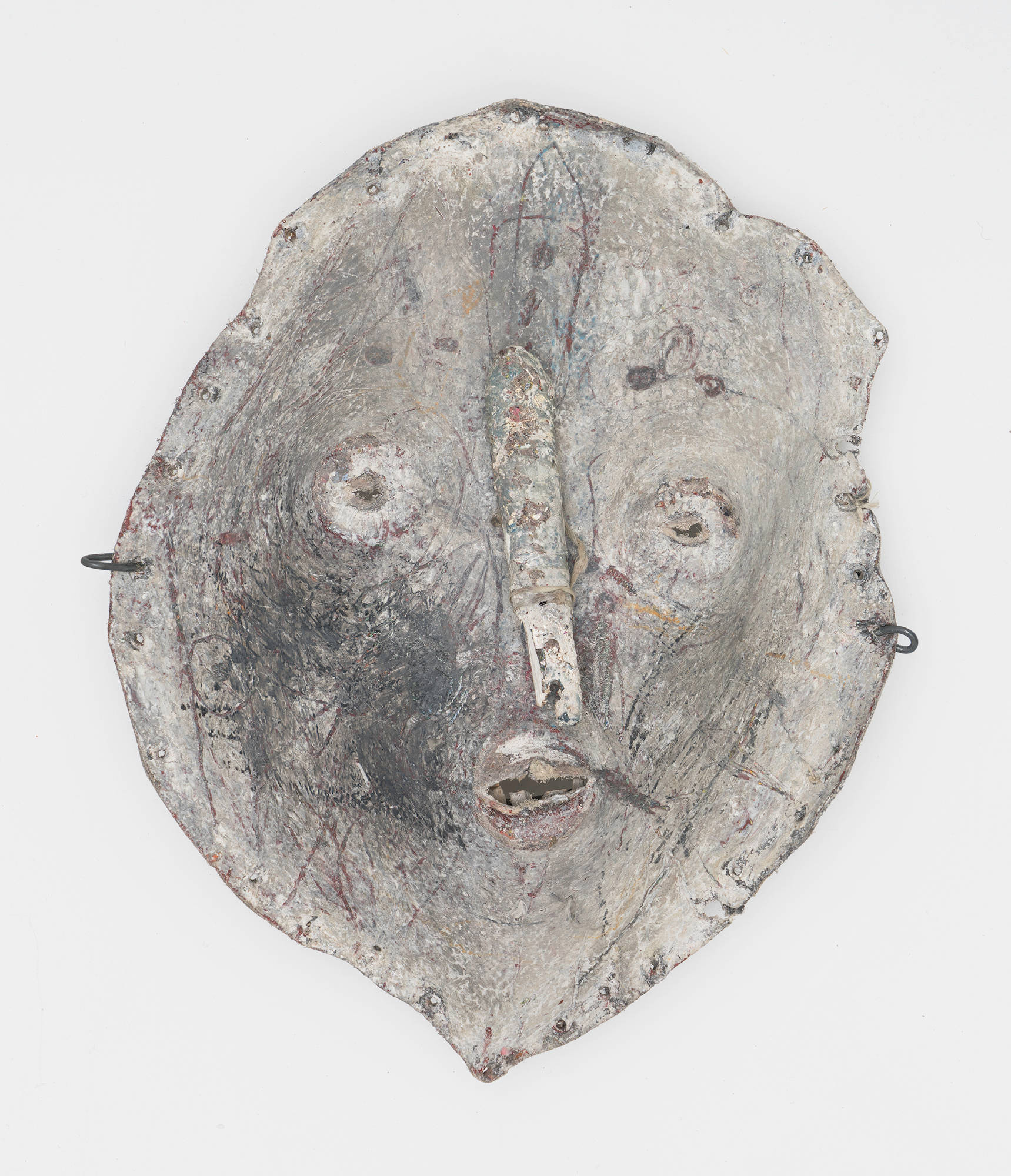 A primarily gray abstract sculpture resembling a partial mask of a face.
