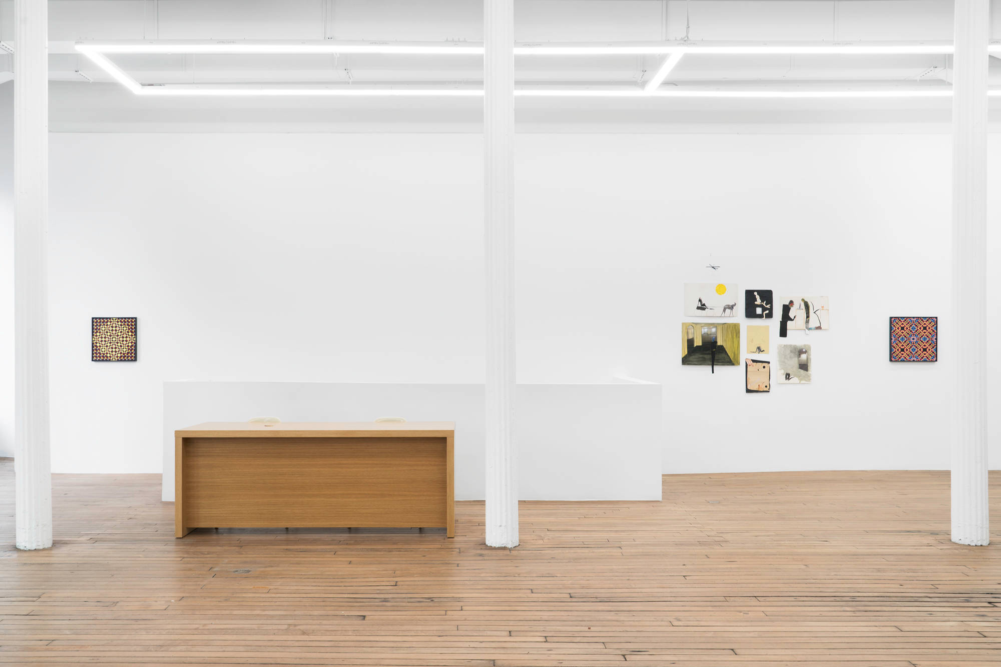 A view of the east wall of the gallery shows 3 large white columns, a wood desk, and a rear wall hung with 2 abstract paintings by Matt Hoyt, and a group of 7 works on paper by Tom Thayer.