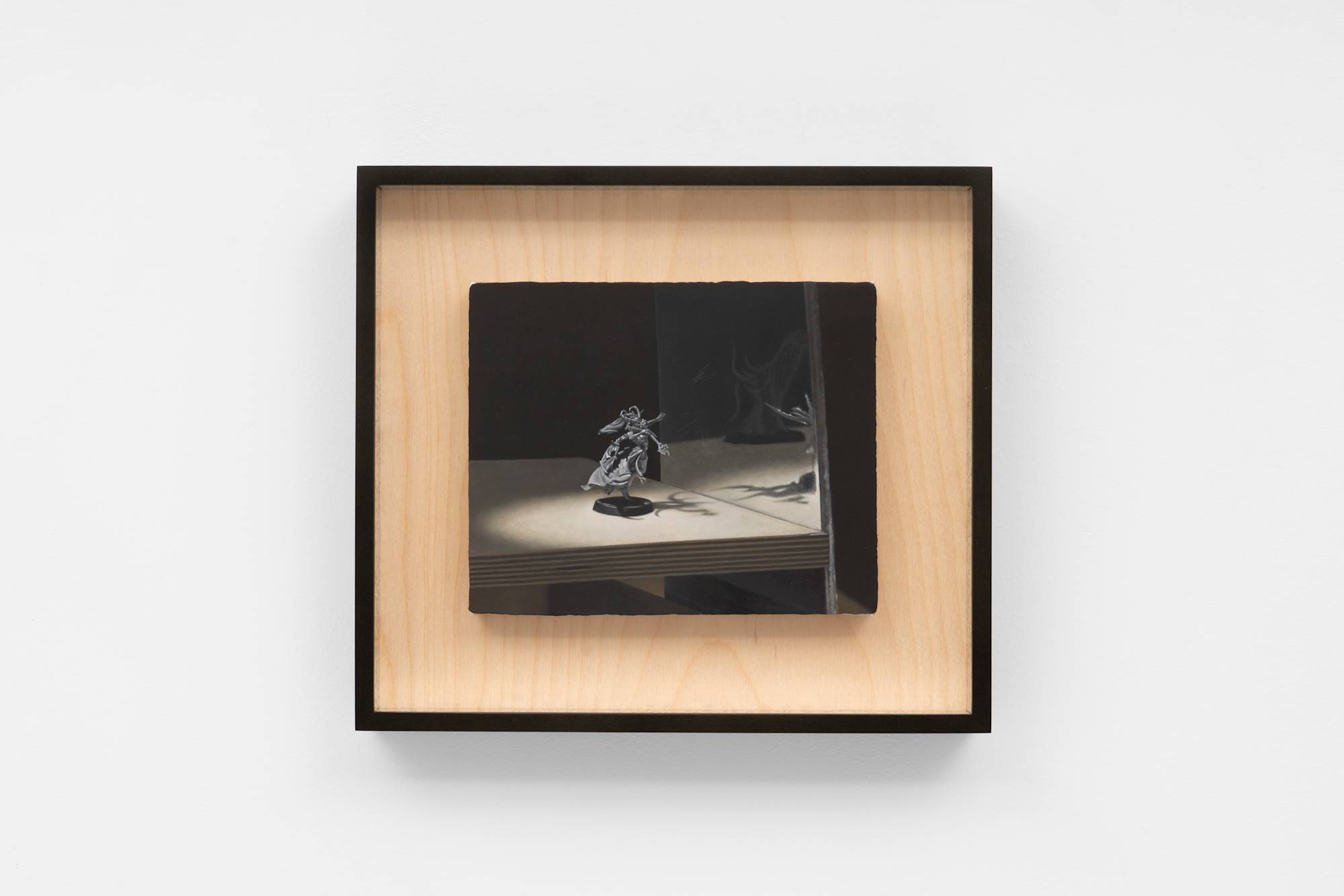 A small oil painting depicting a Warhammer model, spotlit, posed in front of a mirror, standing on a plywood board framed in custom black frame with plywood mat.