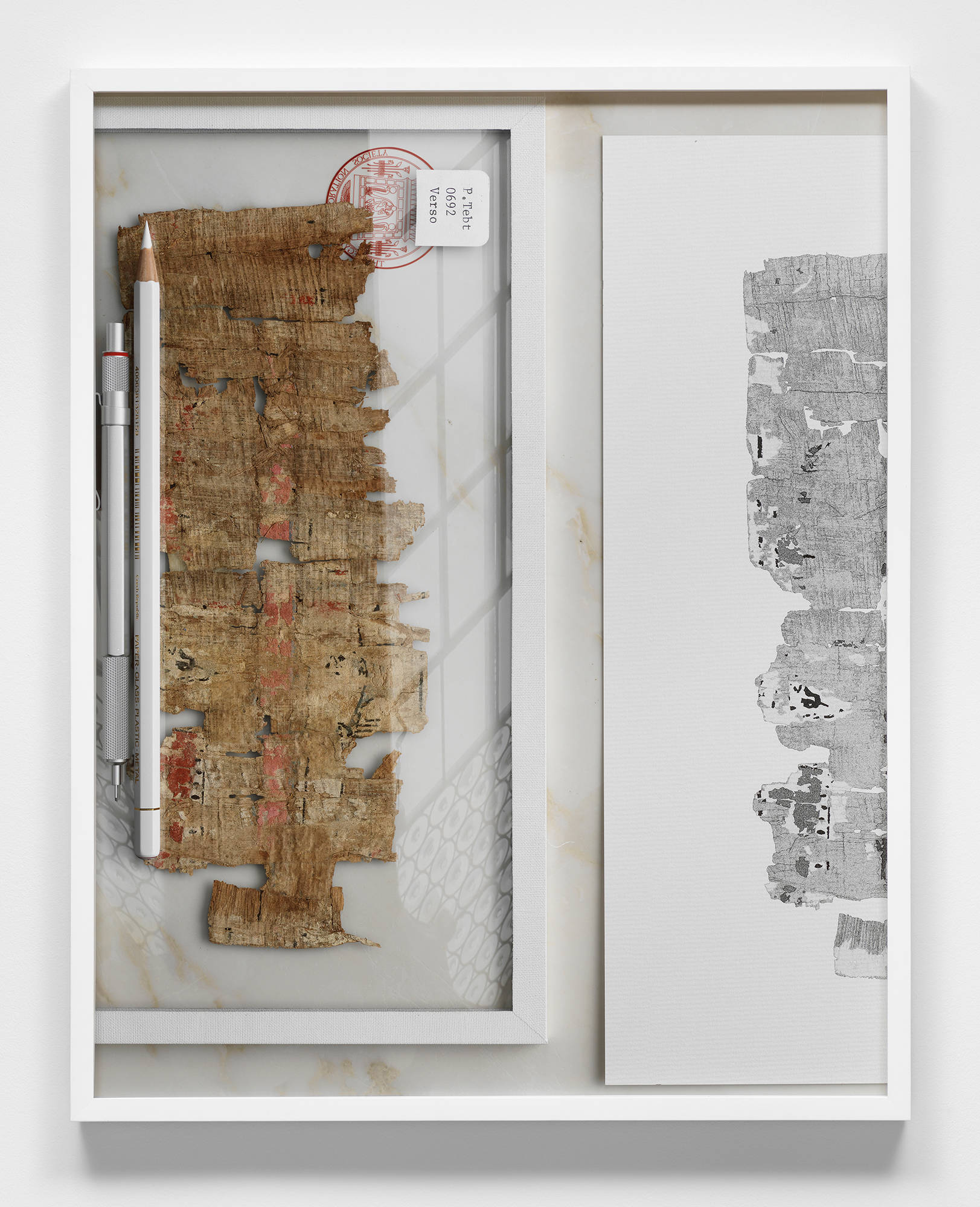 Image of a framed print by Jeffrey Stuker depicting a digitally rendered scene, shot from above, of a piece of papyrus and a drawing of the same papyrus on the right.