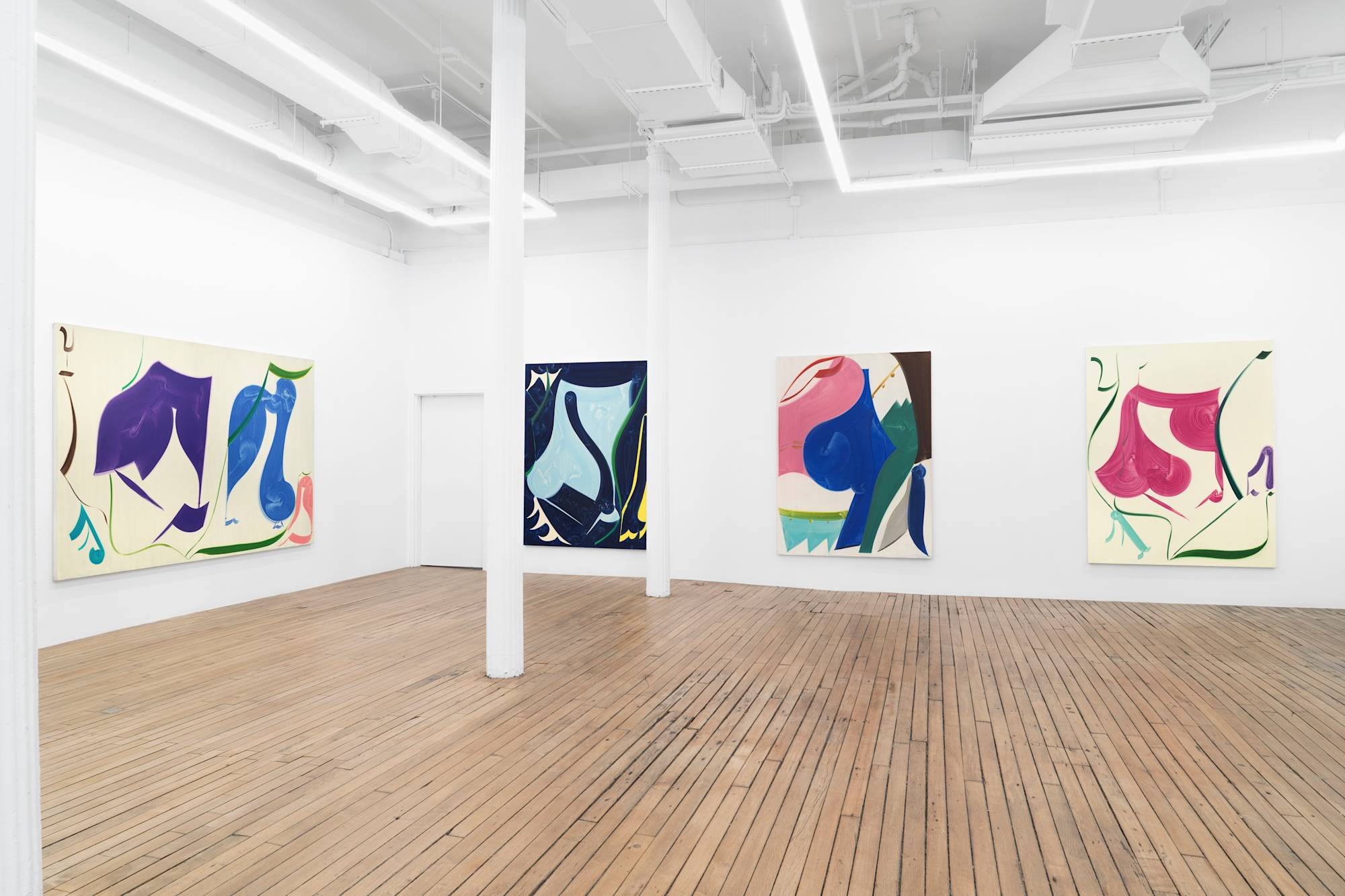 Four abstract paintings of simple shapes and bold colors hang in an art gallery with white walls and wood floor.
