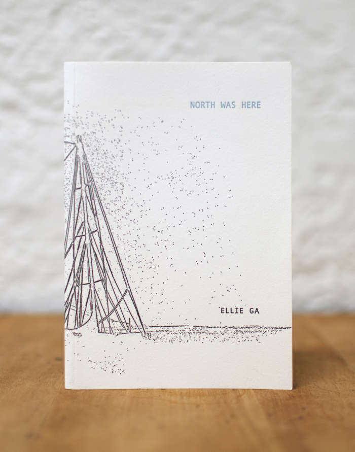 Image of a book by Ellie Ga. The cover has a white background with a drawings of a ship's mast to the left, on the horizon there is "Ellie Ga" printed and at the top right corner of the cover "North Was Here".