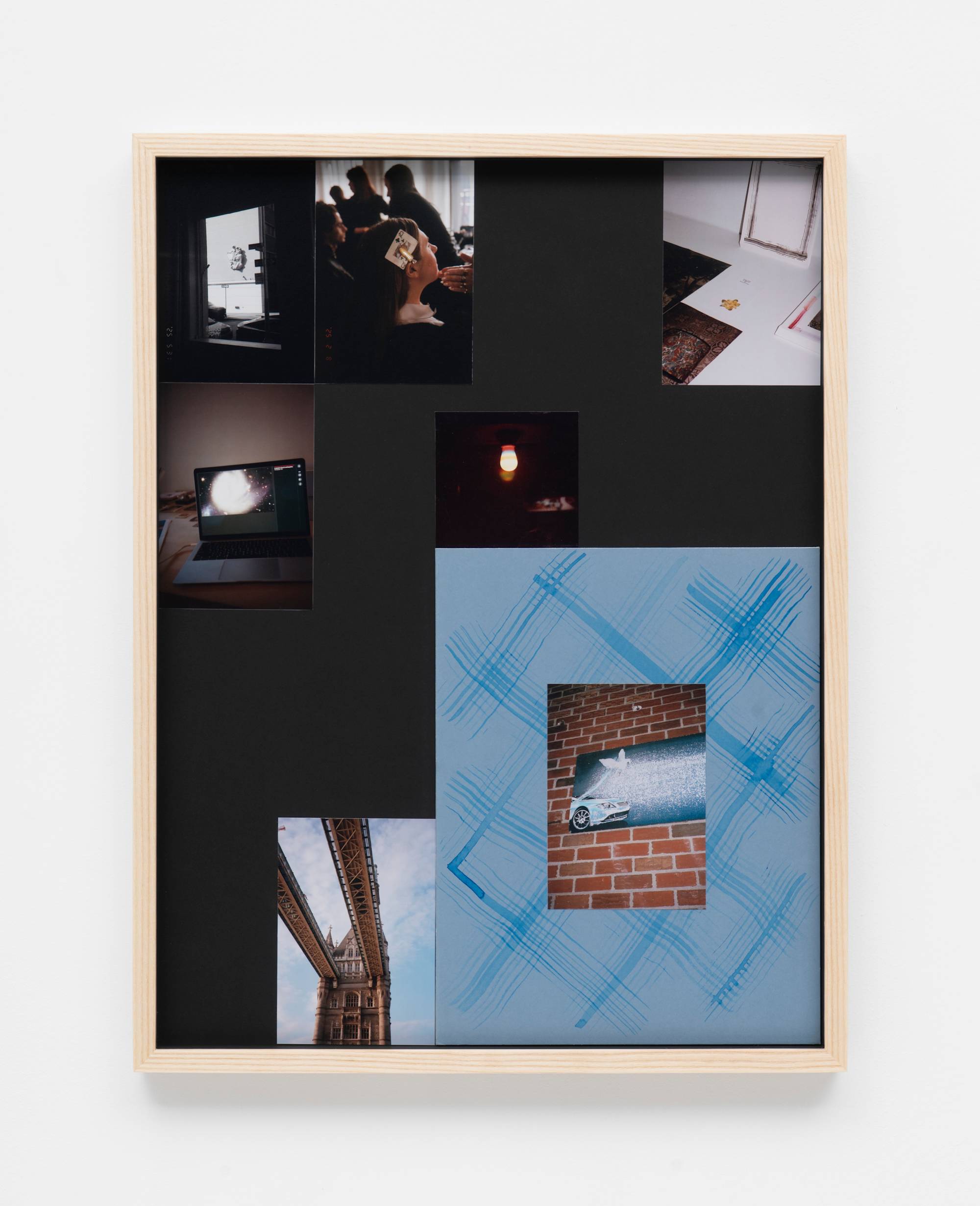 In a wood frame, a series of small photographs and mementos are arranged together.