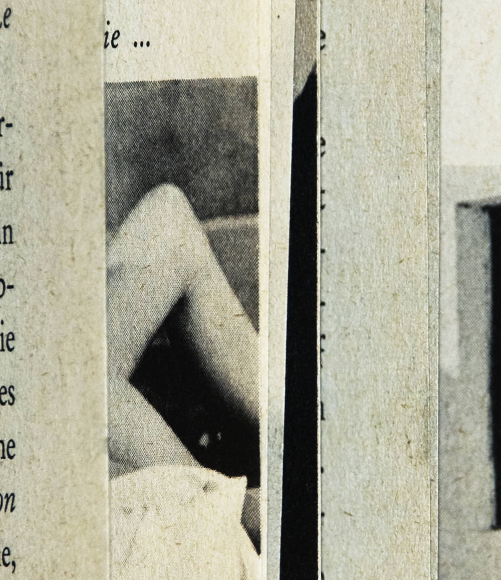 Photograph peering into an open book with the edges of the book's paper creating thin vertical stripes resulting in an mostly abstract image of color and shape. Visible is a cropped image of legs, and small bits of text. All other strips are fairly unrecognizable. The image is black and white.