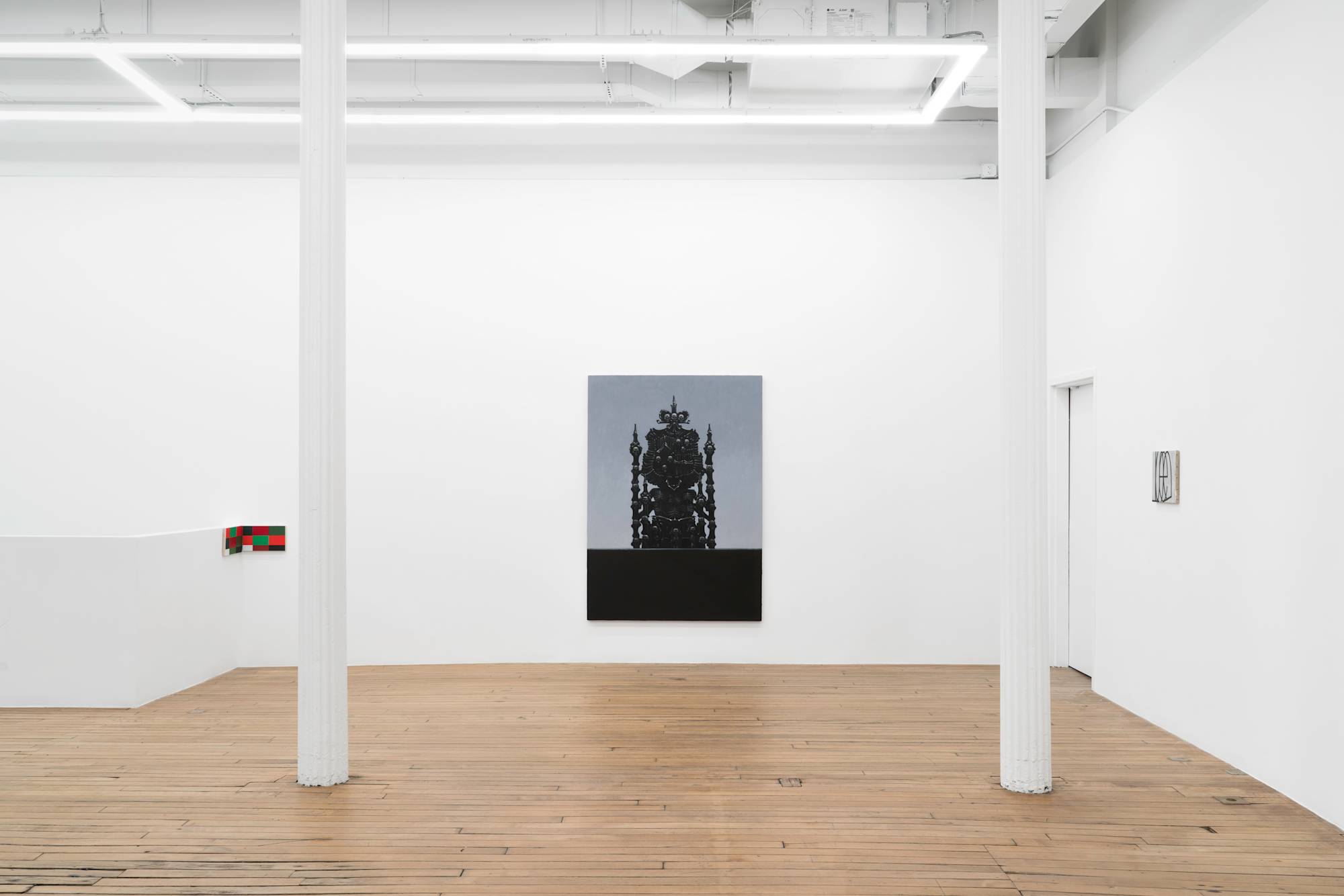 A view of three paintings hanging in a brightly lit gallery.