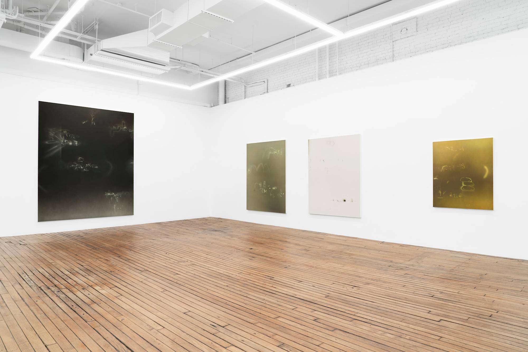 In a large, bright gallery space, four vertical abstract paintings depicting a range of airbrushed marks in solid grounds of color.