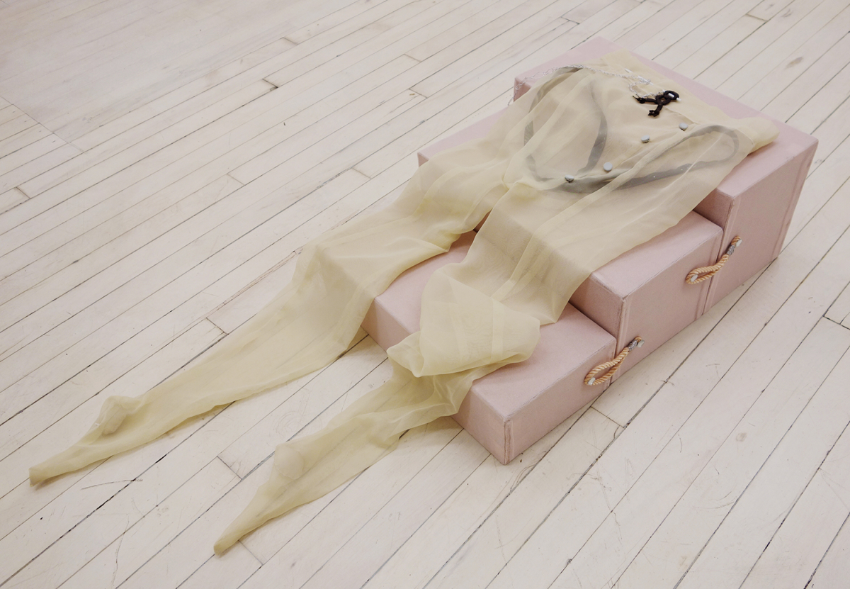 A sculpture made of a set of pink stairs with off-white nylons draped over it.
