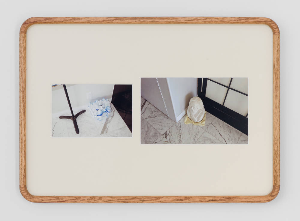 A rounded wooden frame containing two small photographs of domestic spaces. 