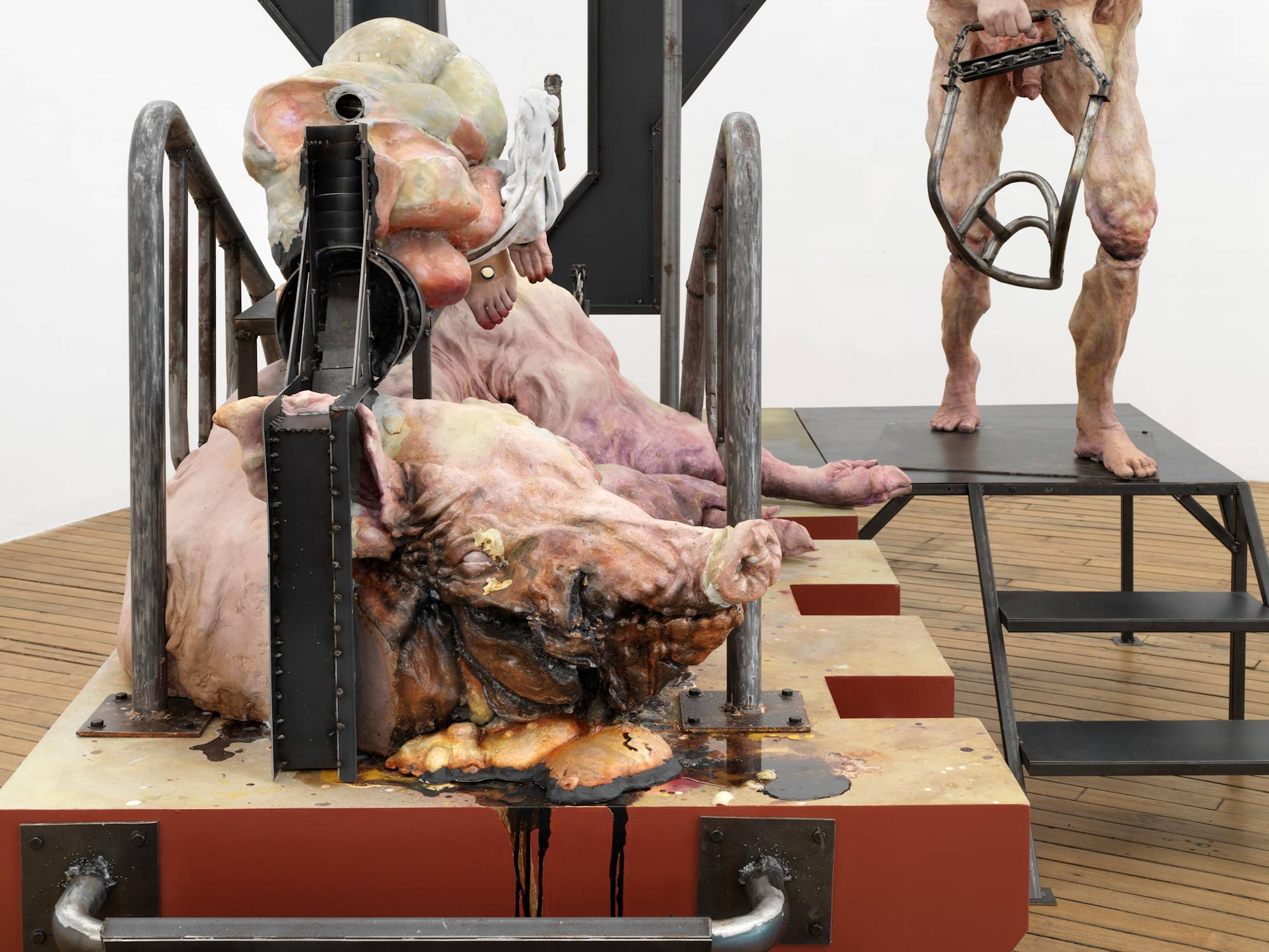 Close up view of an abstract sculpture of a pig and human form with various pieces of steel piercing them.