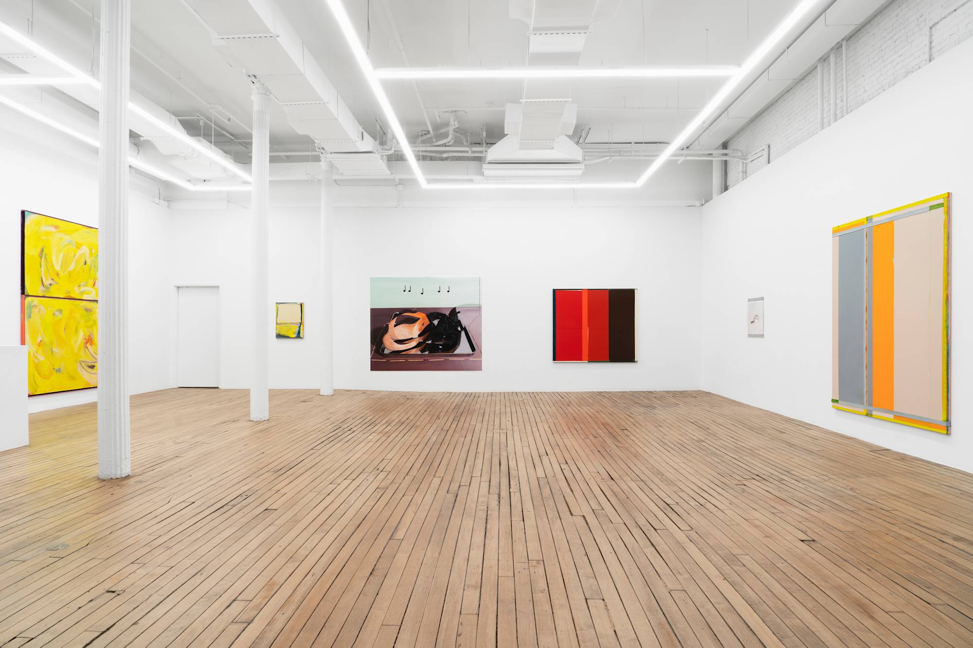 A large gallery space filled with evenly spaced large abstract paintings and photographs.