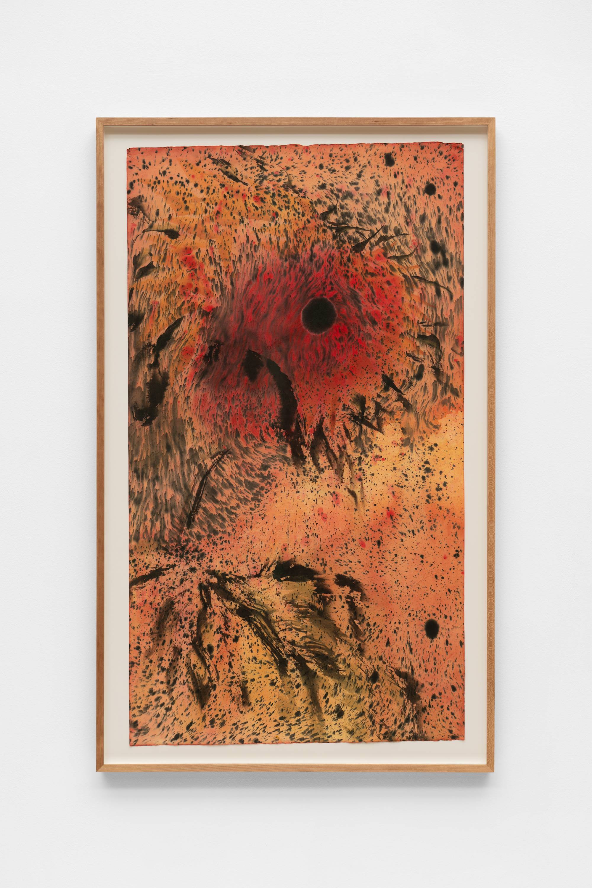 An ink painting of two diffused sunflowers, with dark orange and black centers. Black speckles of ink swirl around the two heads of the sunflowers on a dark-orange and ochre background. The frame and the wall the work is mounted on is visible in the shot.