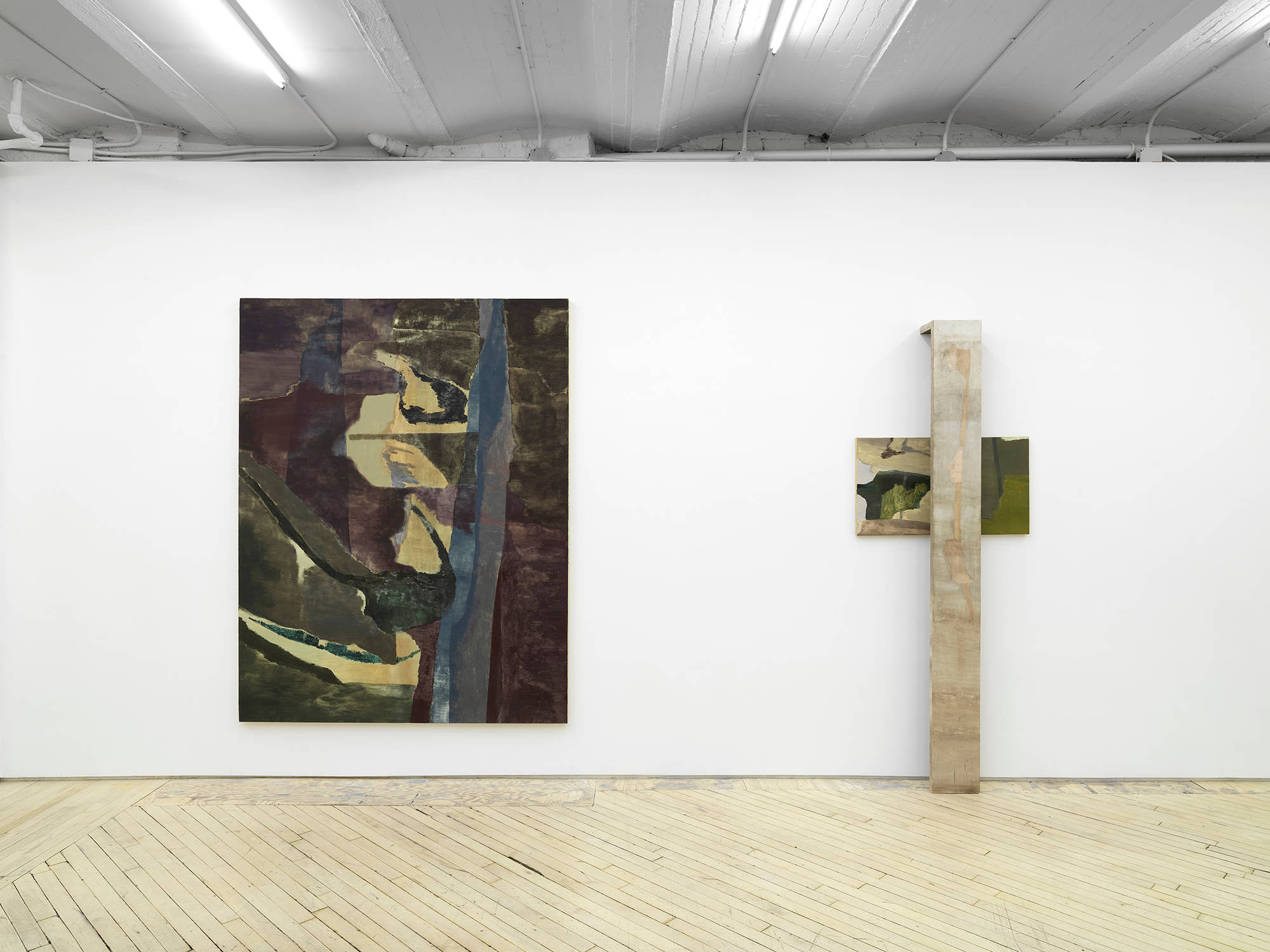 A large gestural, abstract painting installed next to a vertical leaning painting and sculpture rendered in earthly hues.