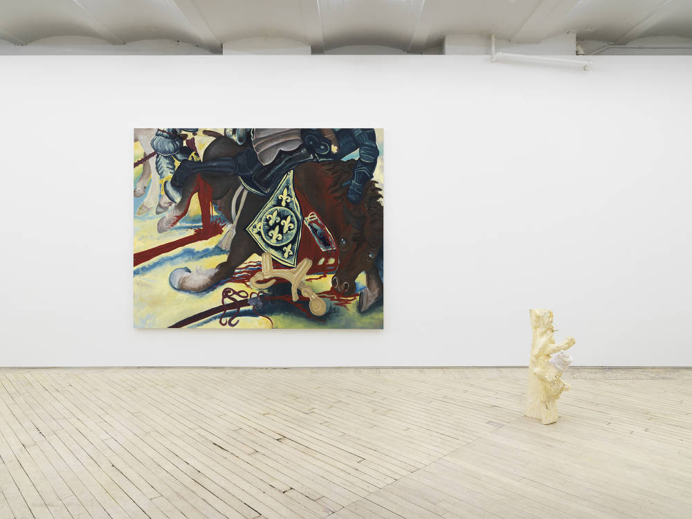 In a gallery space, a large painting is hung on a white wall depicting an abstracted scene of a cartoon-like horse collapsing in a battle field. To the right on the floor is abstract sculpture with a light-than finish. One of the protrusions coming out of the main form has a sock hanging over it. 
