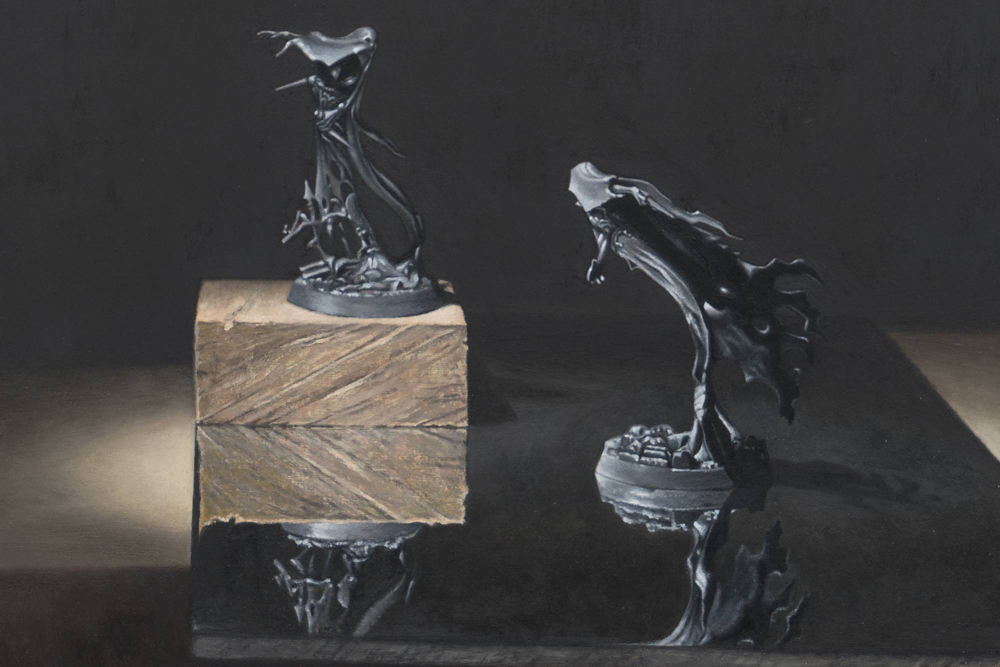 Ian Miyamura painting depicting two unpainted Warhammer figures against a black background. The figures stand on a mirror showing their reflections. There is a wood block underneath the figure on the left.