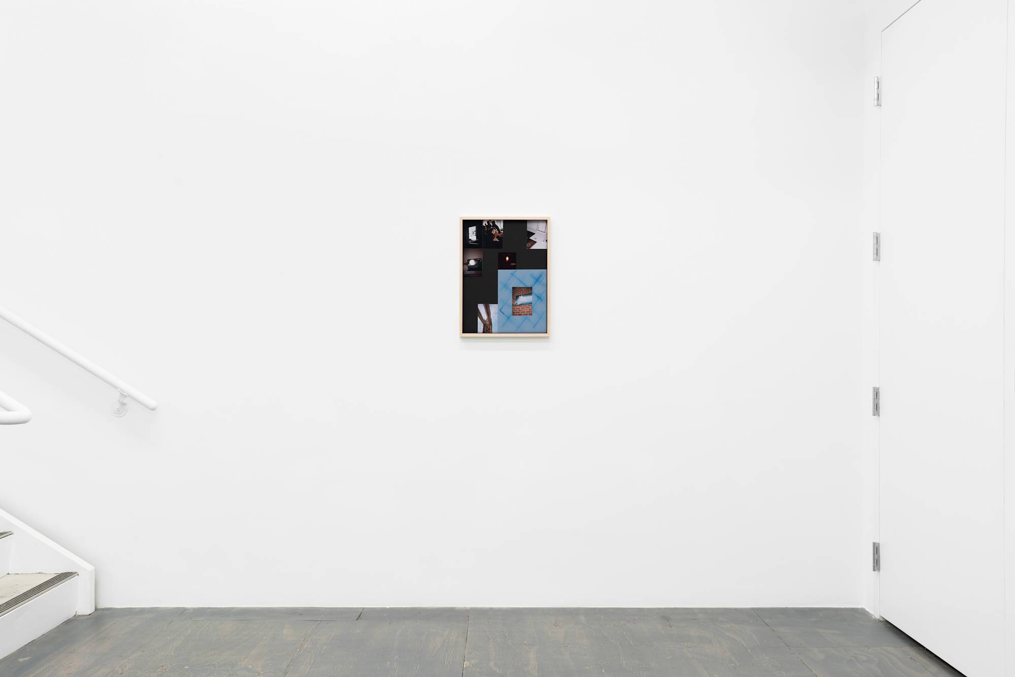 Placed in the center of a gallery wall next to a staircase, a framed object containing multiple images and momentos in a unique arrangement.