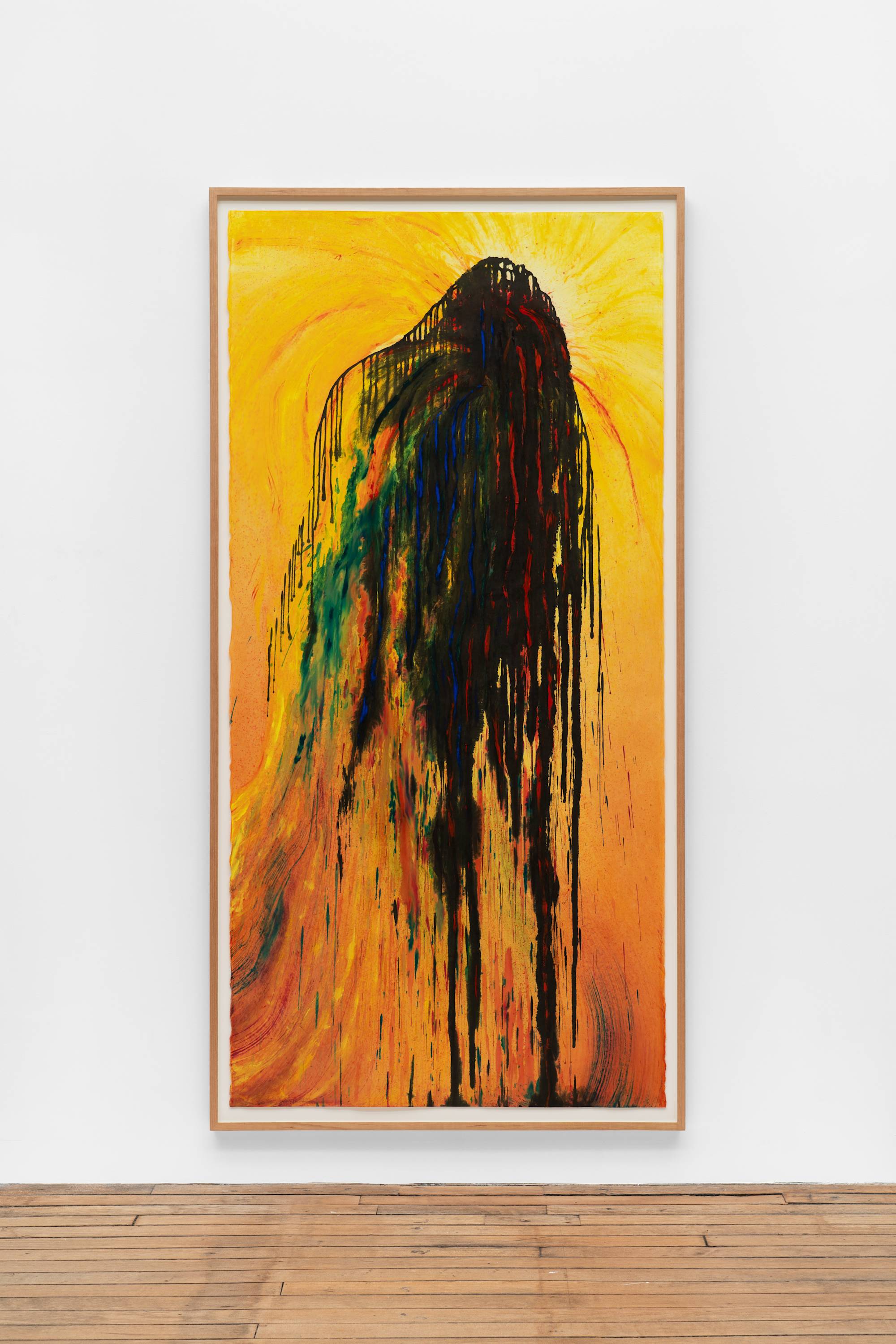 An ink painting consisting of a background of washes of yellow to dark orange, with a large splatter of black ink that flows down to the bottom of the composition. There are smaller streaks of green, blue, and red encompassed in the black splatter. The top of the splatter has a lighter yellow surrounding it and radiating outward, halo-like. The frame and the wall the work is mounted on is visible in the shot.