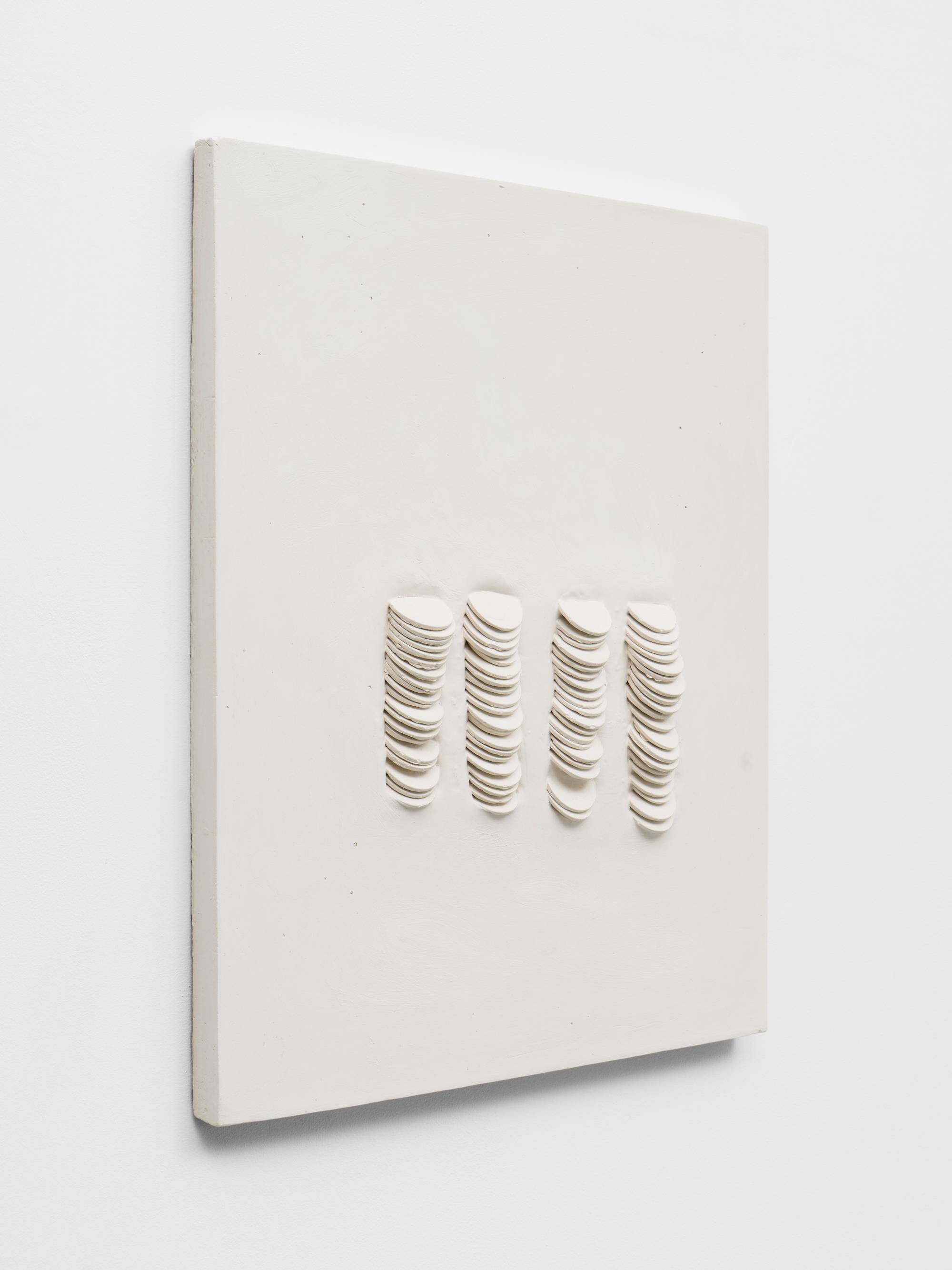 Angle view of a wall mounted white plaster sculpture featuring 80 cast dollar coins.