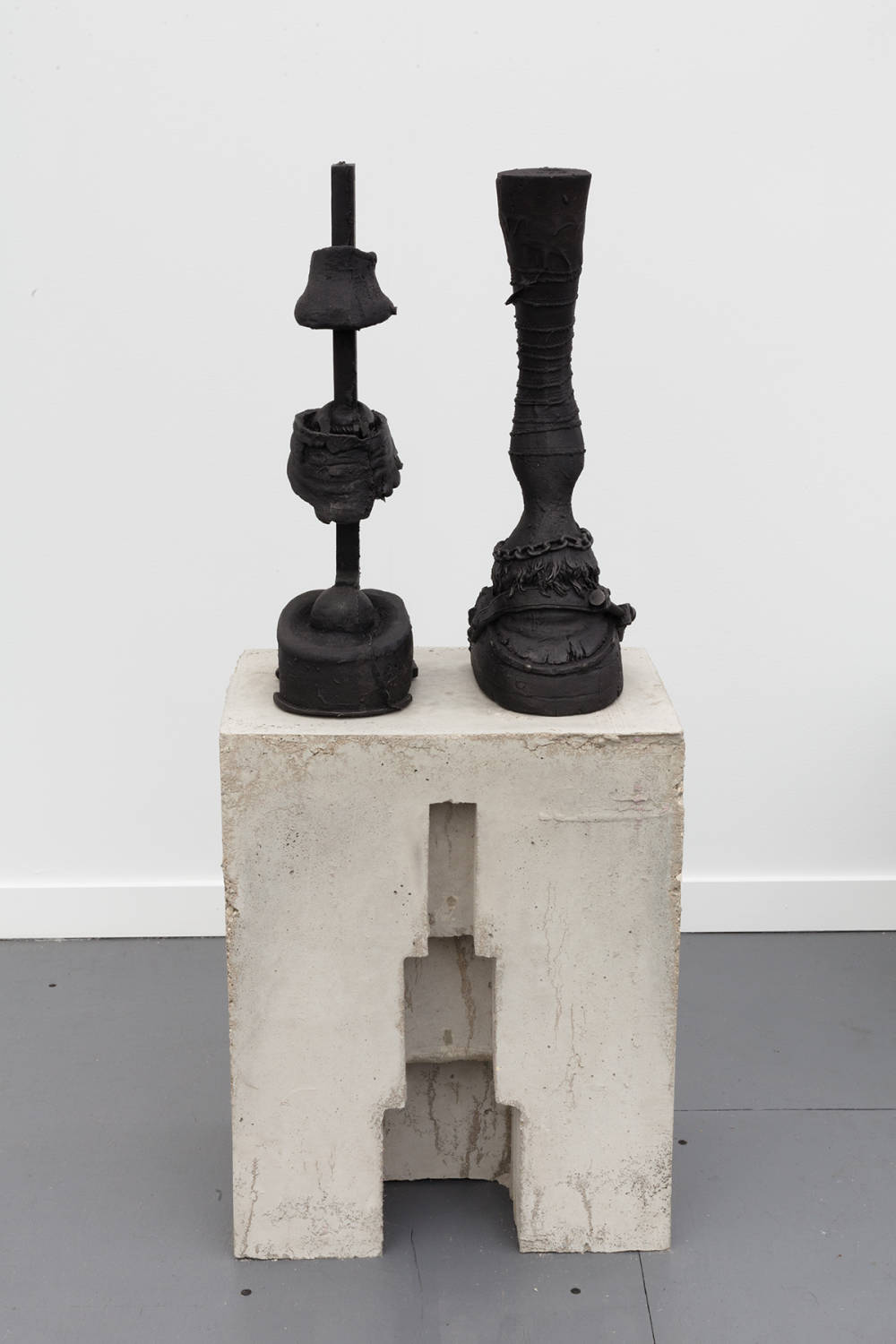 Installation view of cast iron and concrete sculpture, depicting a disembodied horse hoof on top of a concrete plinth.