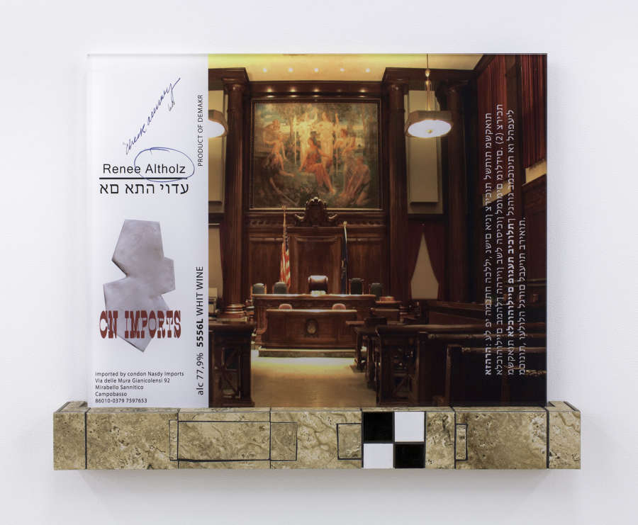 On a white wall, a wall hanging sculpture. The image containers a printed photograph of an interior courtroom. There is the text "Renee Altholz." An import description taken from a white wine label. At the bottom of the sculpture is base constructed out of granite floor tiles. 