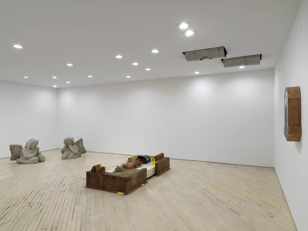 Image of a solo exhibition by Libby Rothfeld showing a number of sculptures on the ground and two metal cylinders installed in the ceiling.