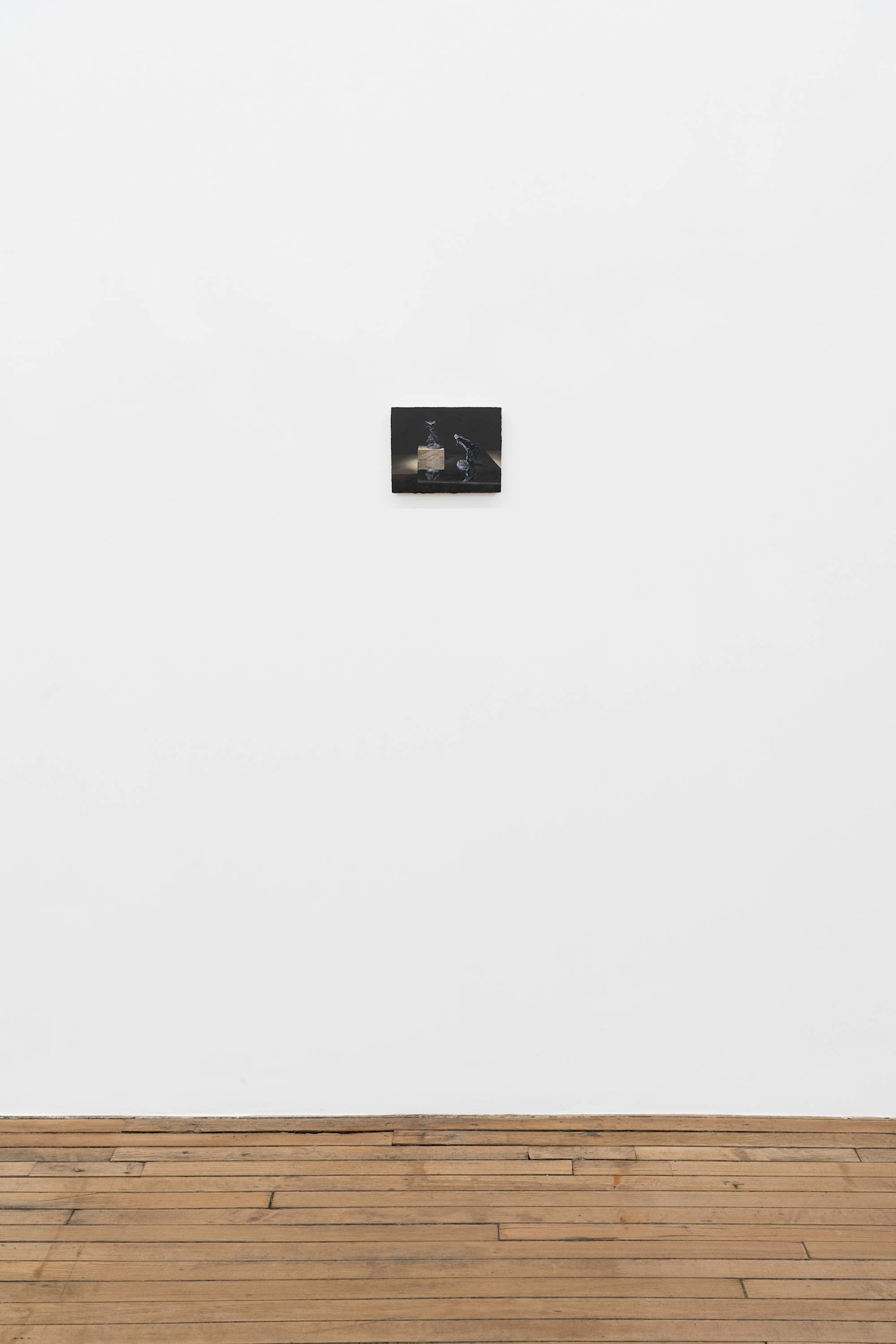 Ian Miyamura painting depicting two unpainted Warhammer figures against a black background hangs in a gallery above a wood floor. The figures stand on a mirror showing their reflections. There is a wood block underneath the figure on the left.