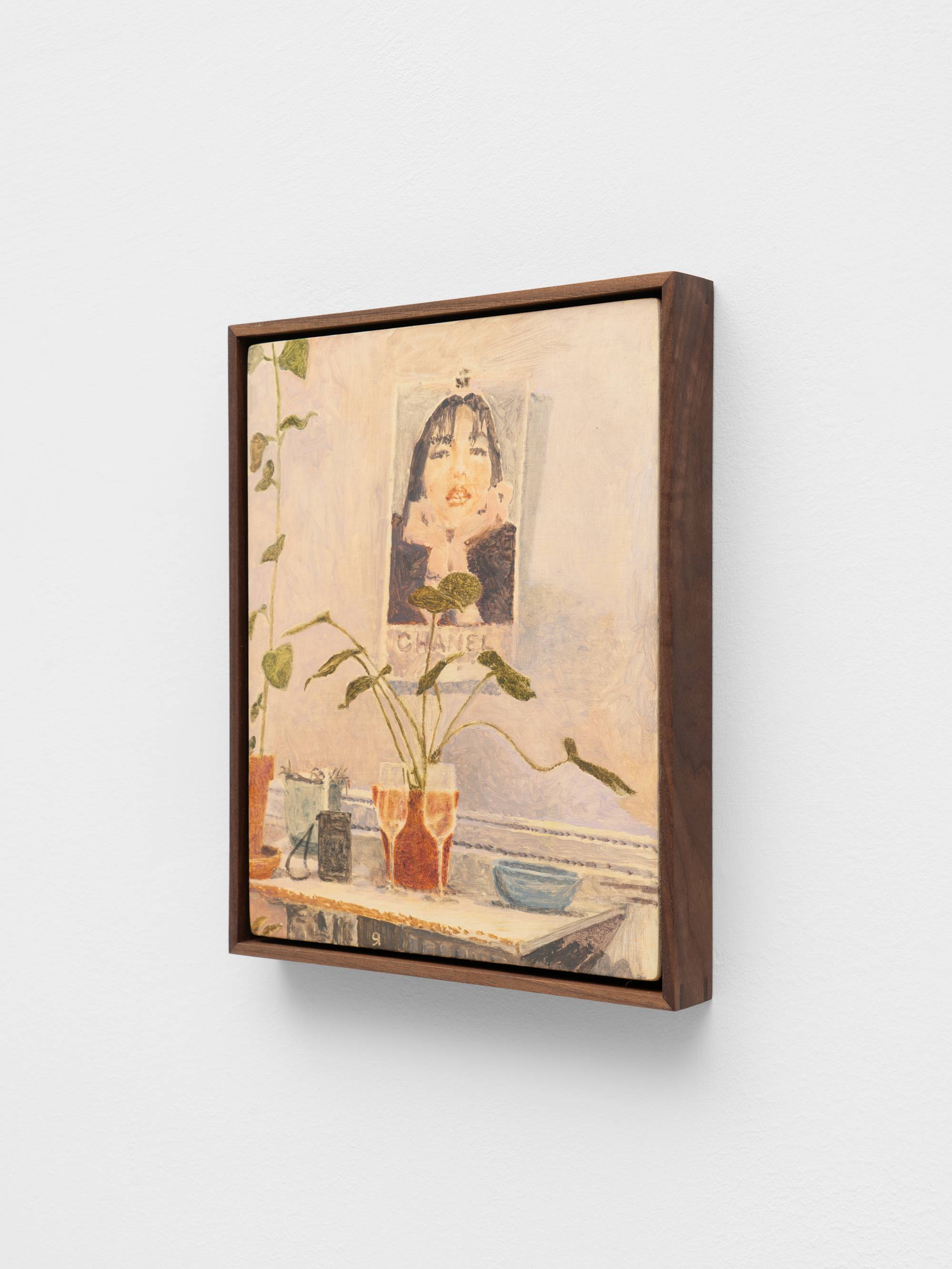 A small, dark wood framed painting of an apartment interior featuring two full champagne flutes on a table, plants, and a Chanel poster.