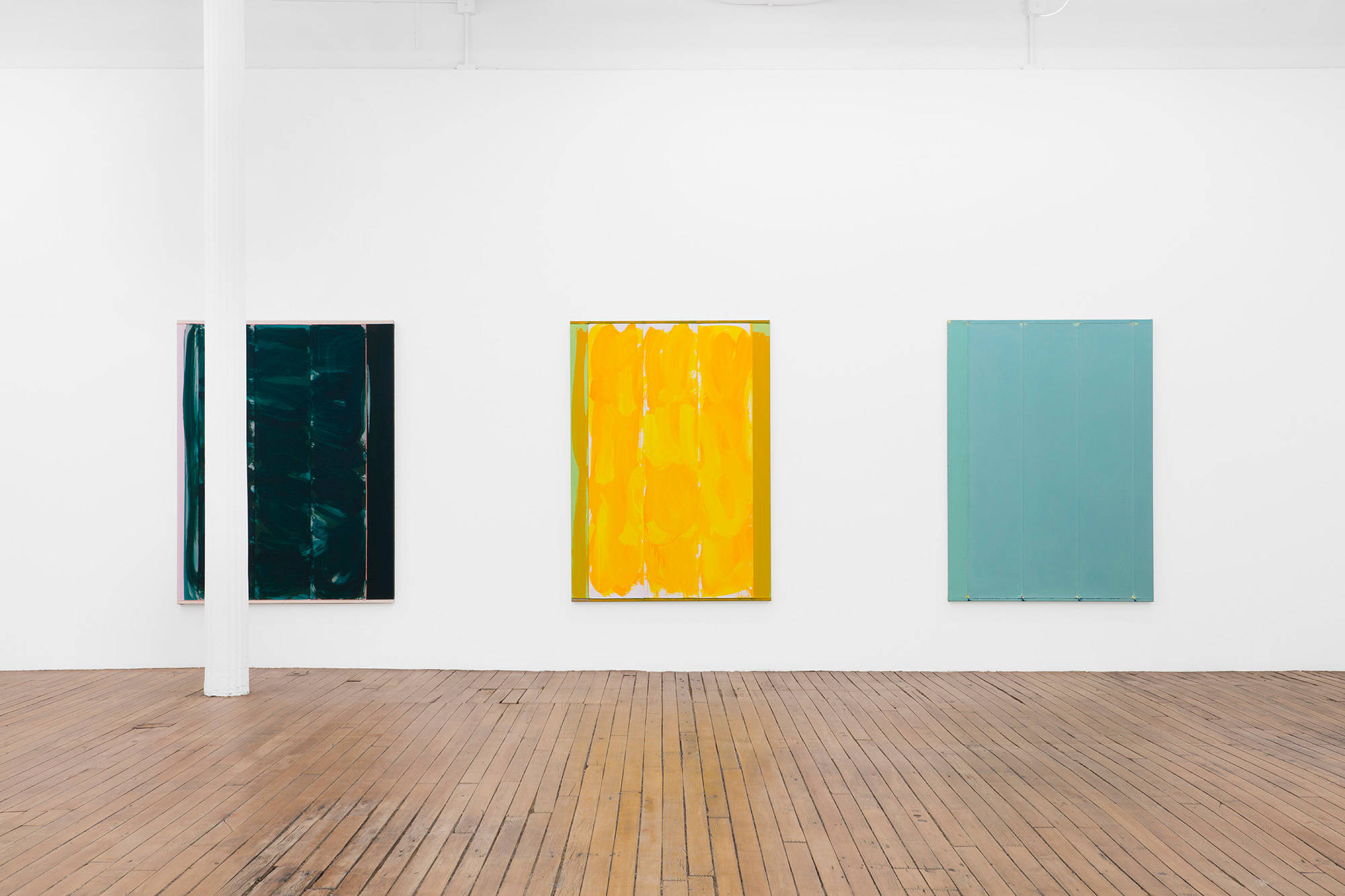 Three large abstract paintings hung evenly spaced apart depicting mostly monochromatic fields of color.