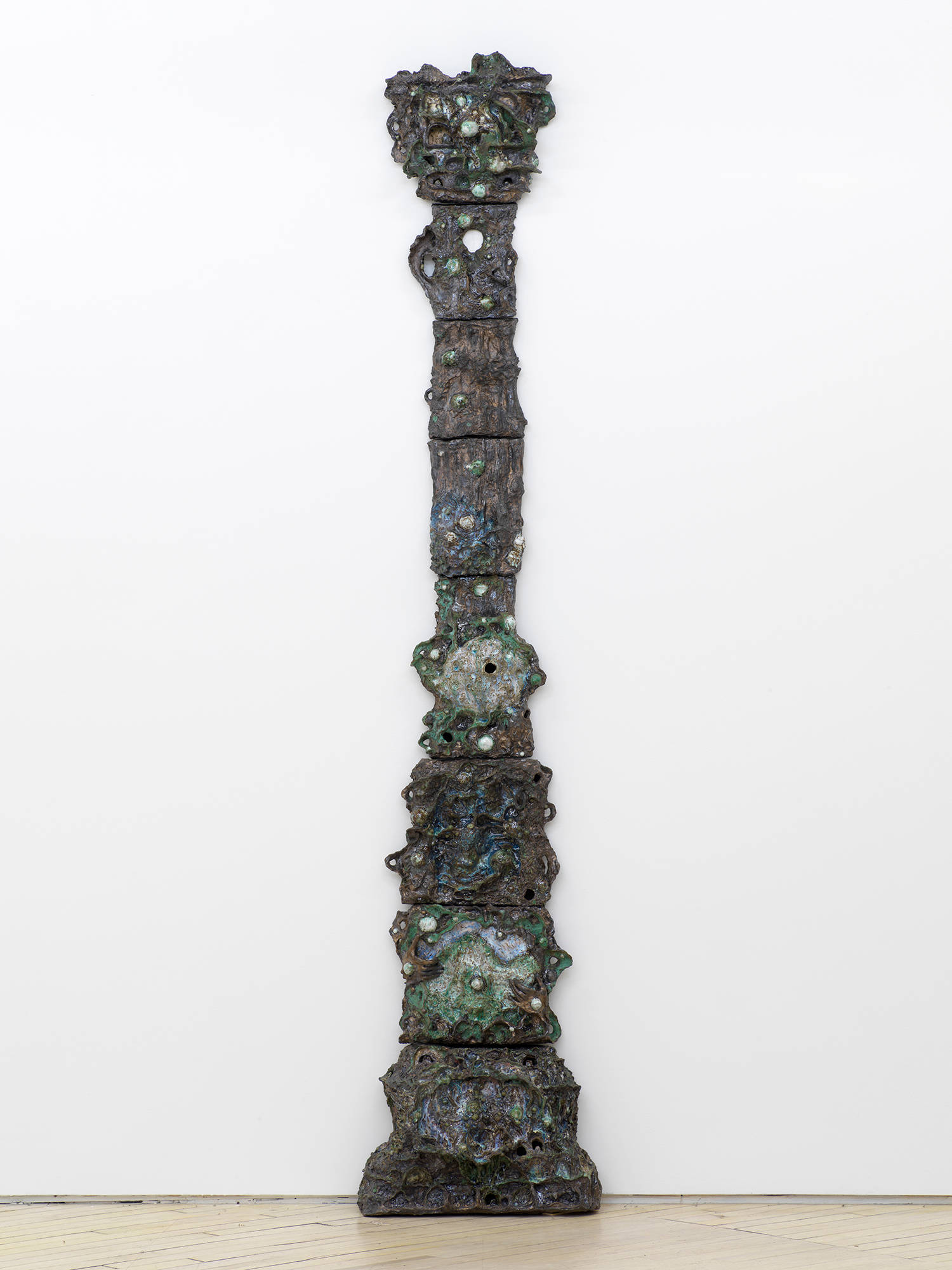 A tower of abstract ceramic sculptures installed in the shape of an expanding column.