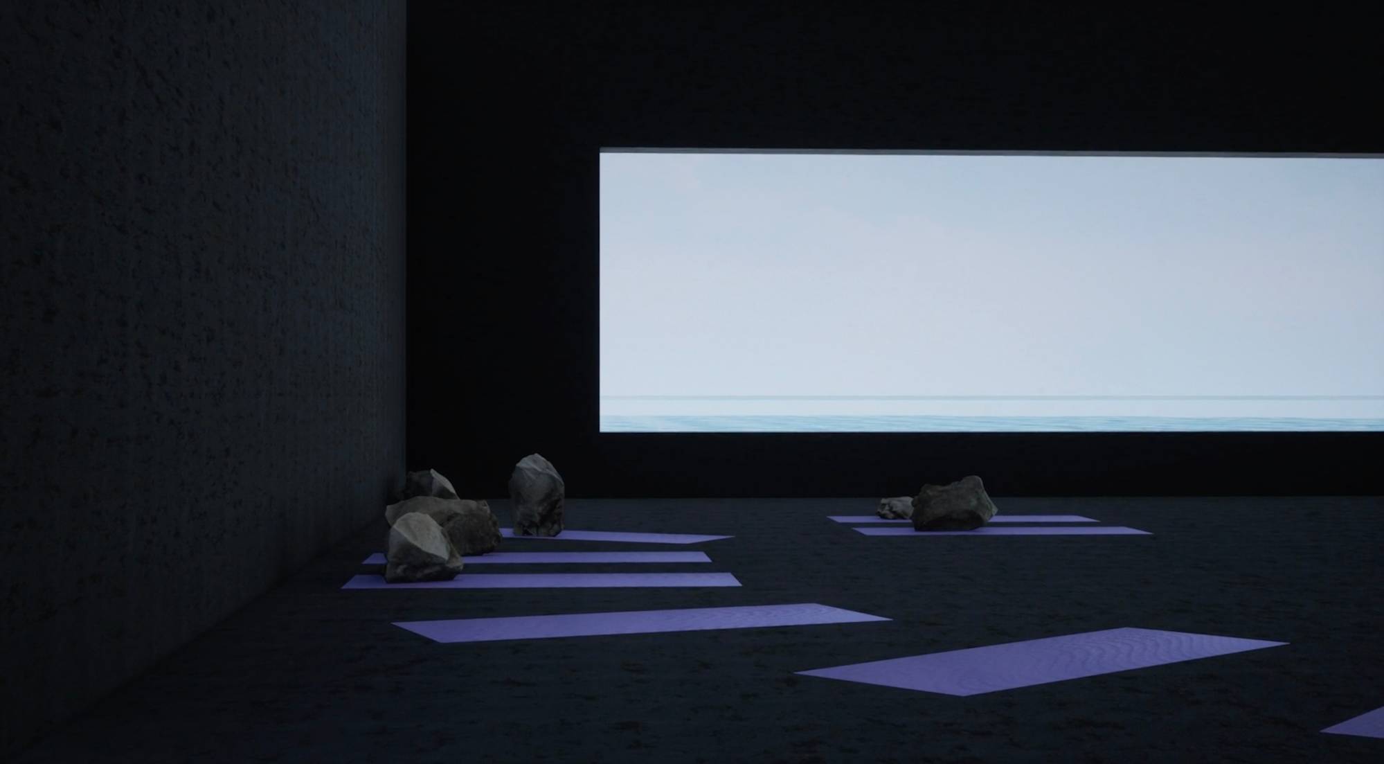 A screenshot from the film "MERCY" that depicts a dark room with a large, wide window. There are seven yoga mats. Large boulders sit on five of the yoga mats. The walls are black. The scene from the window is clear blue sky.