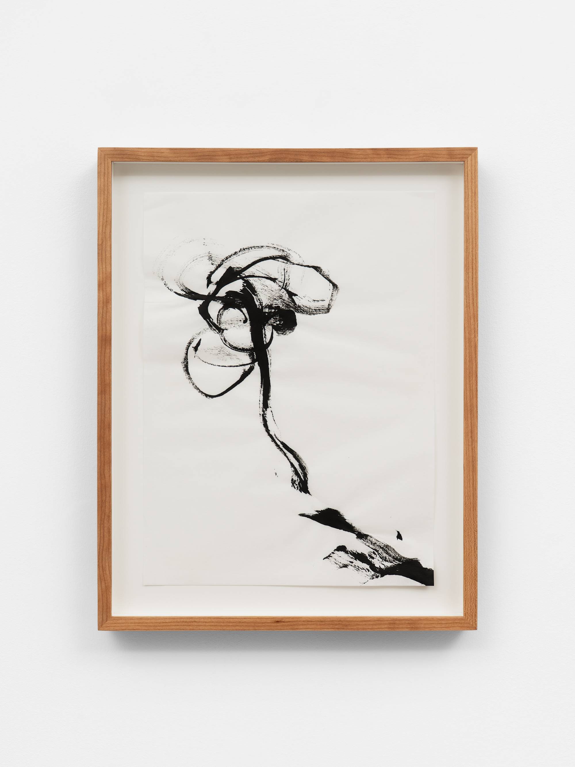 An ink painting on white paper of an abstracted flower rendered in black ink. The composition is minimal, with only gestures of petal, leaf, and stem. The frame and the wall the work is mounted on is visible in the shot.