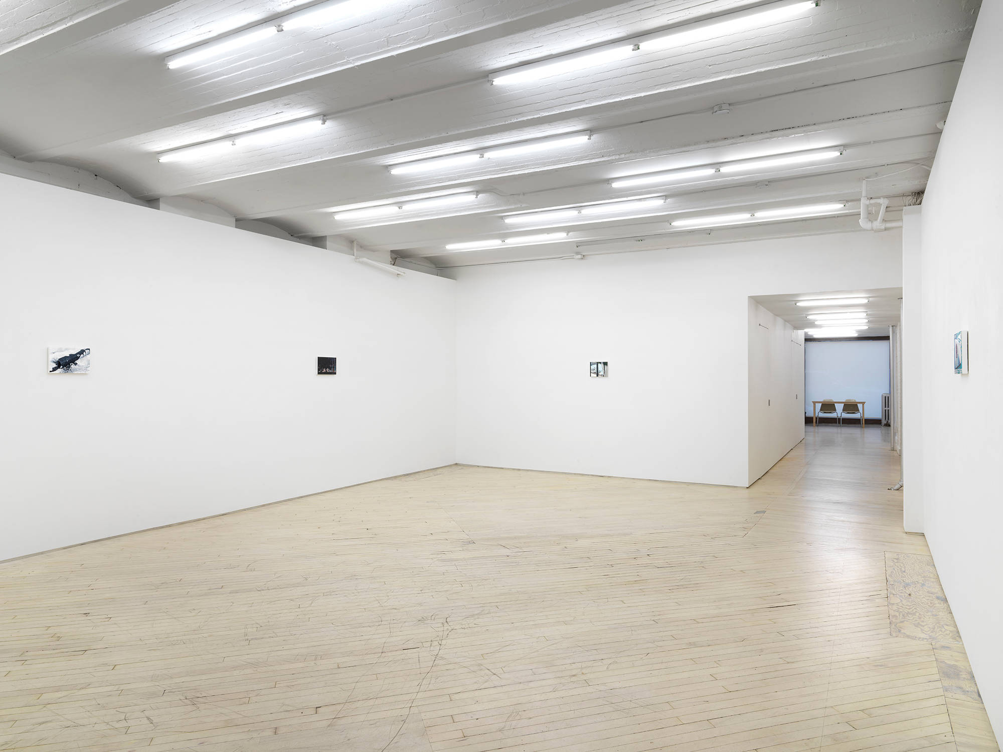 Installation view of an exhibition of paintings by Caleb Considine. Four small paintings hang on the walls of an art gallery.