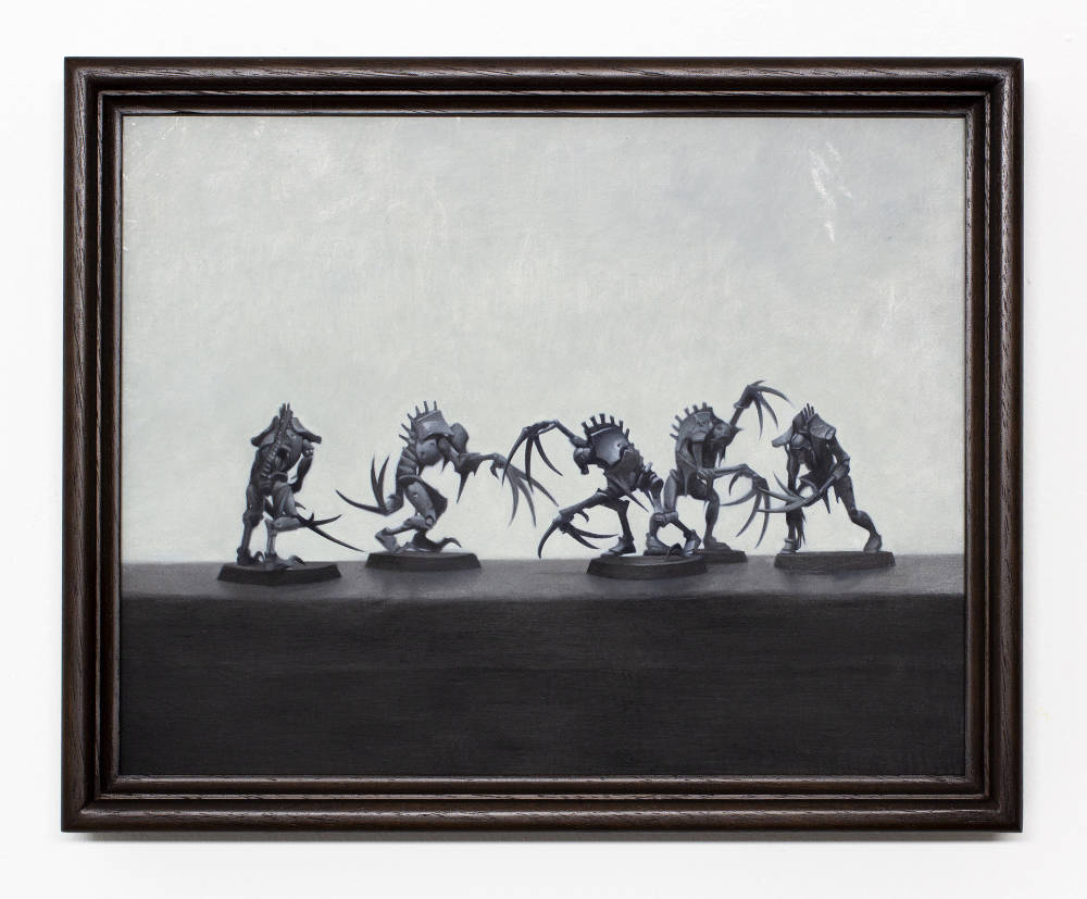 A still life arrangement of small figurines arranged in battle painted in a range of grays. 
