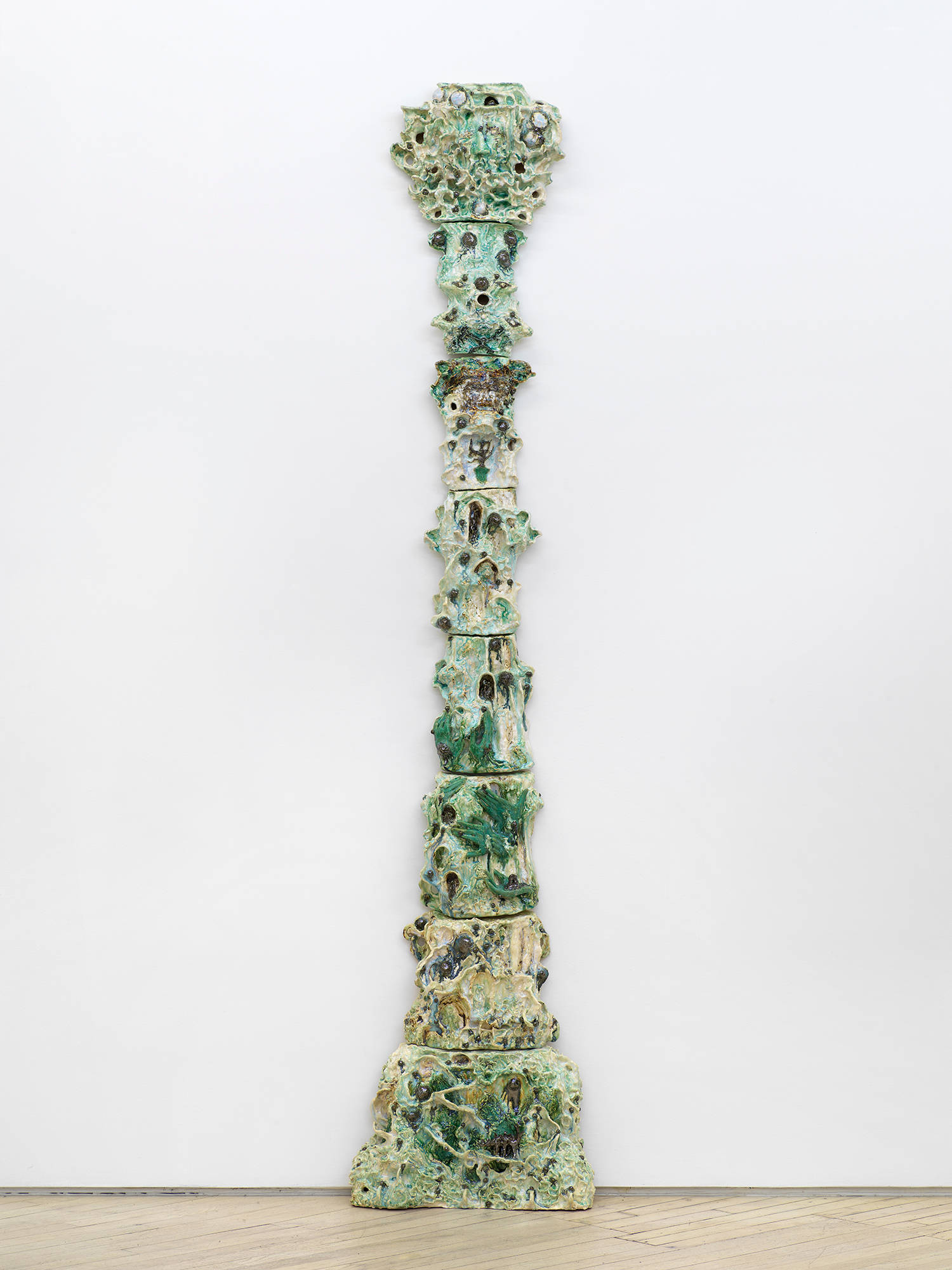 A tower of abstract ceramic sculptures installed in the shape of an expanding column.