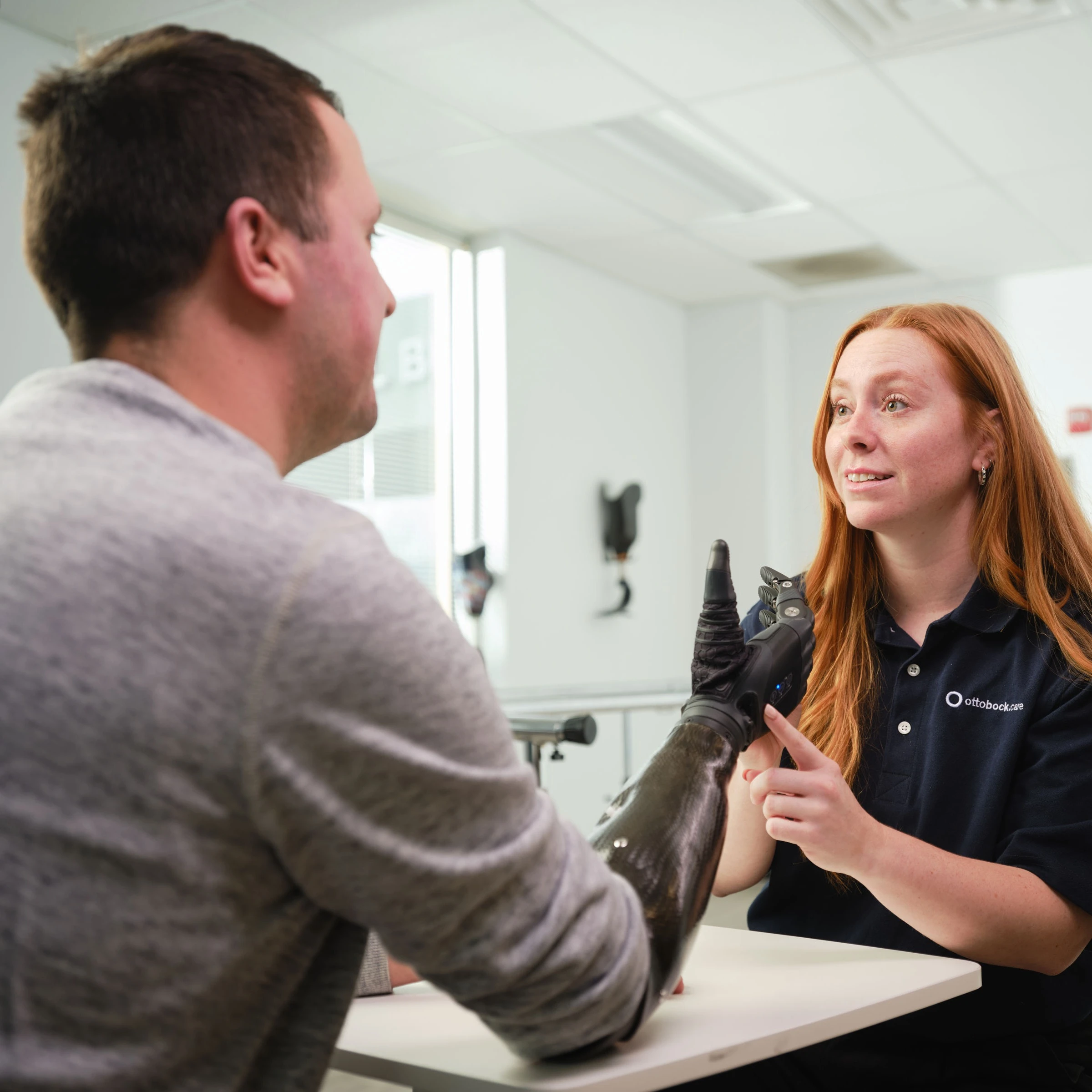 A Certified Prosthetist Orthotist (CPO) and Clinical Support Staff consulting on a prosthetic arm with an amputee patient