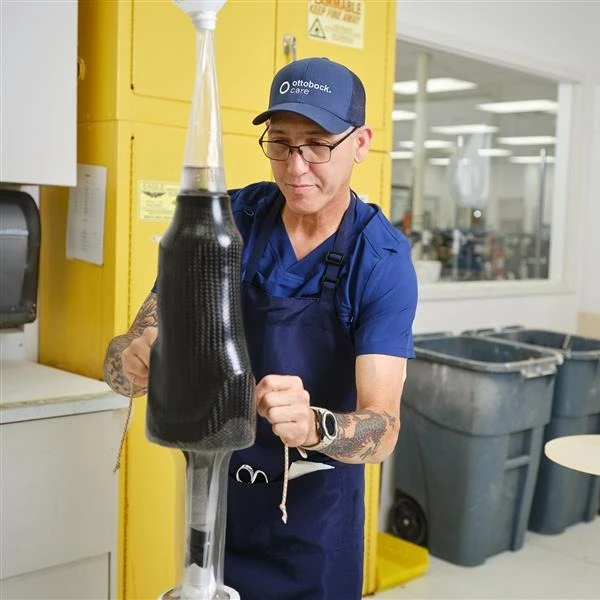 Un protésico certificado de Ottobock que elabora un encaje protésico personalizado de fibra de carbono en un laboratorio especializado de fabricación interno