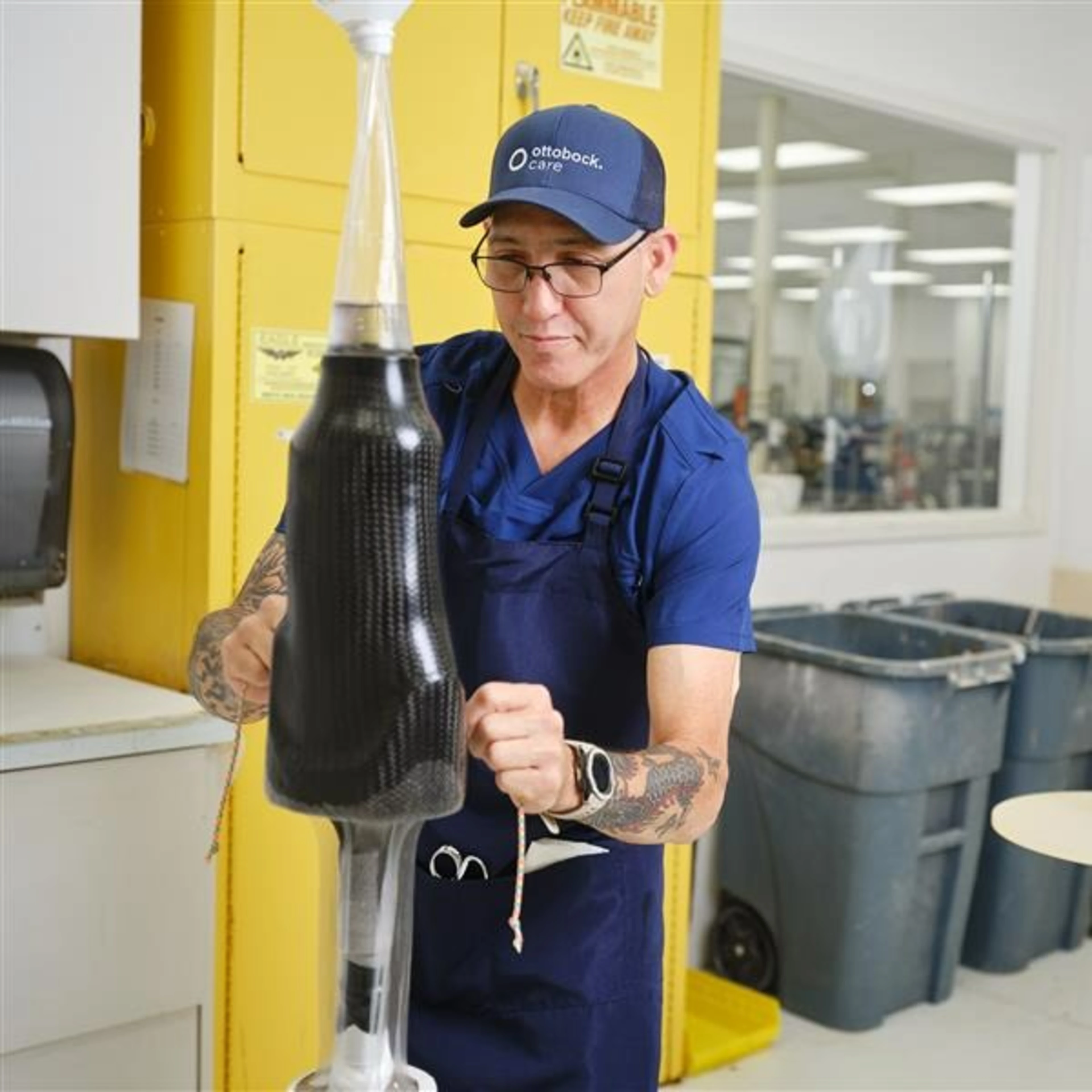A Certified Ottobock prosthetist crafting a custom carbon fiber prosthetic socket in a specialized, in-house fabrication lab