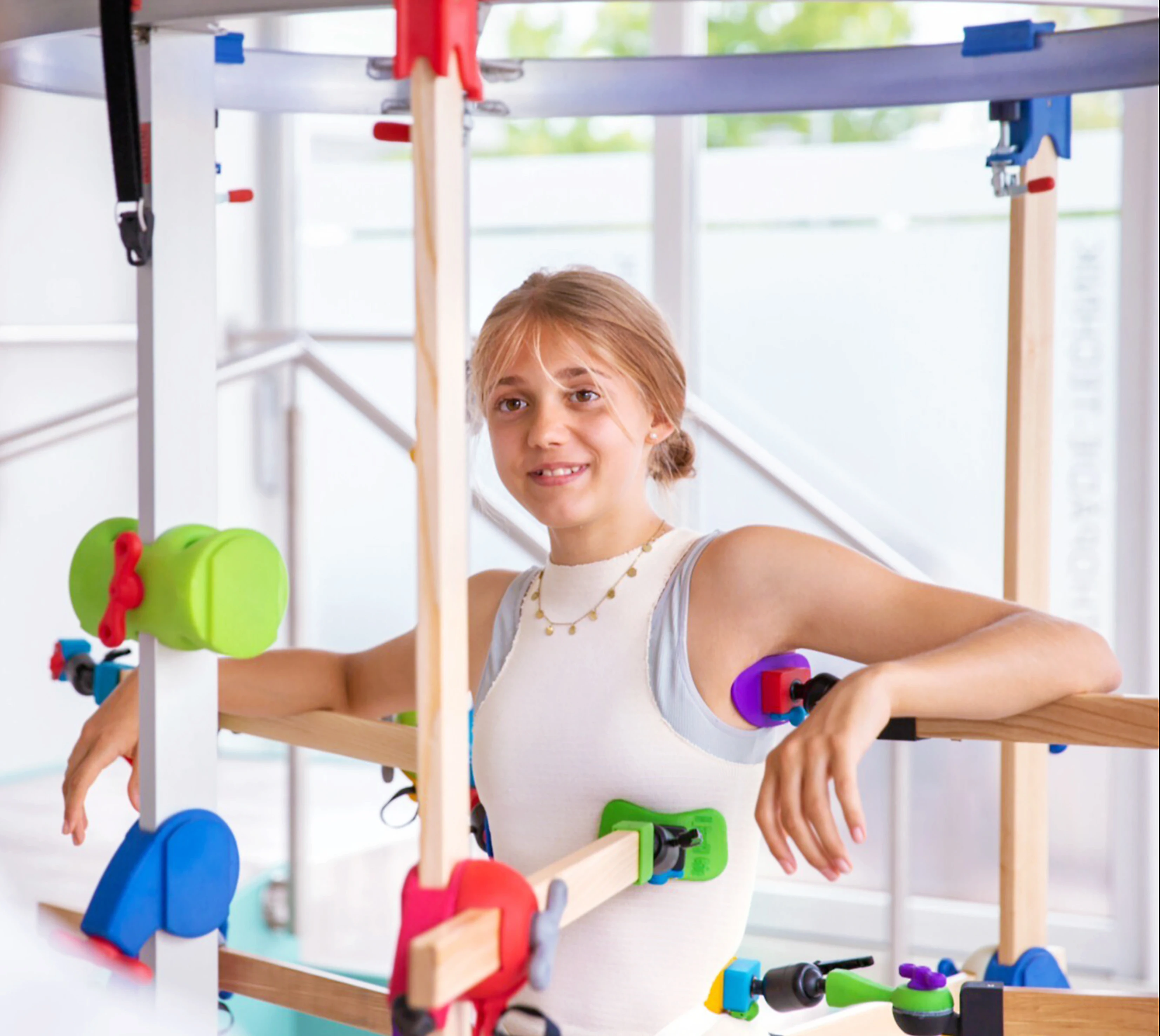 Person standing inside rehabilitation equipment used for physical therapy or mobility training.