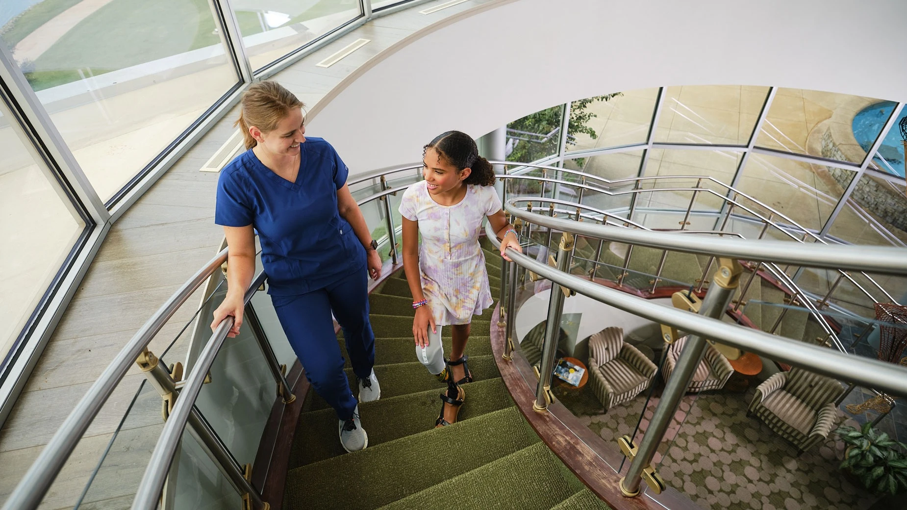 A prosthetic leg pediatric patient walking upstairs with an Ottobock Care clinician in the Scott Sabolich Ottobock Care Oklahoma City, OK location