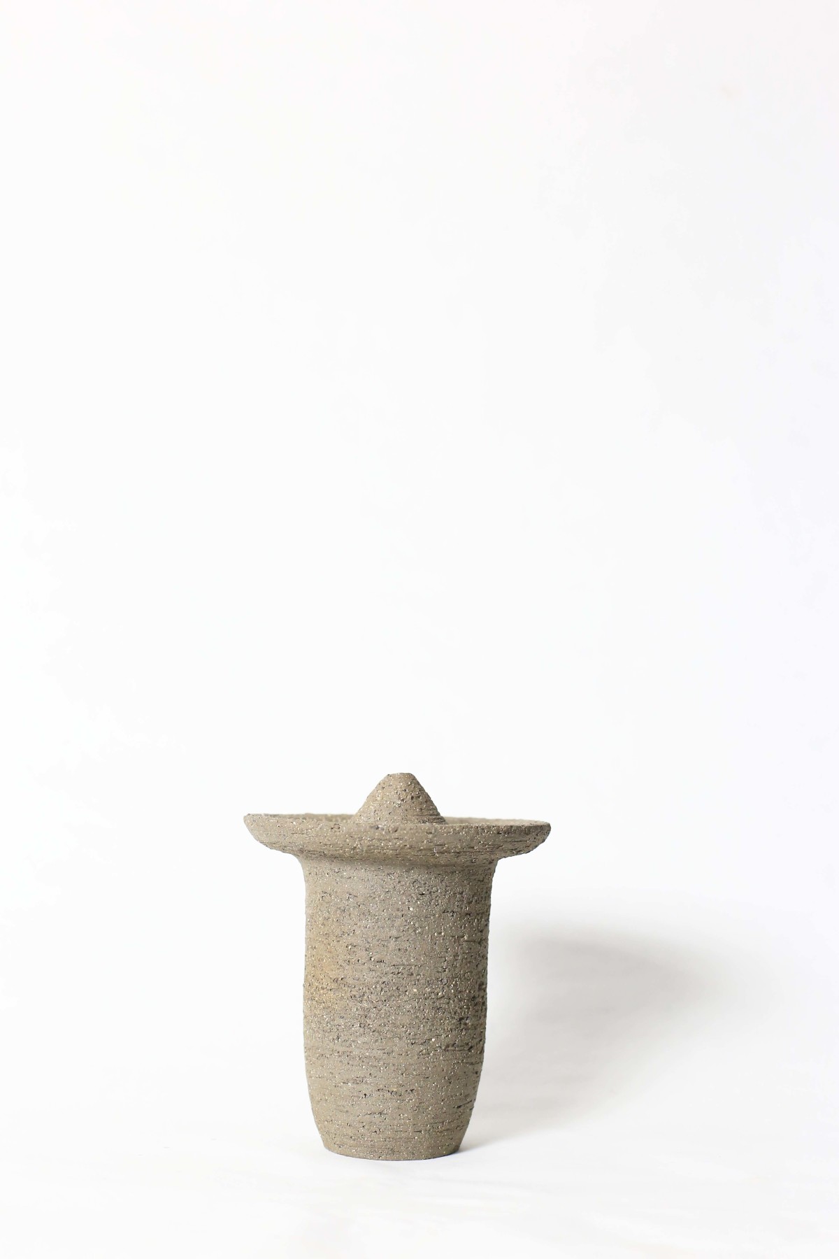 Ufo shaped gray ceramic vase on a white background 1