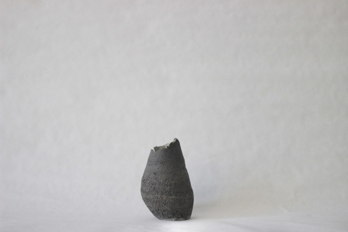 bellied black ceramic vase on a gray background