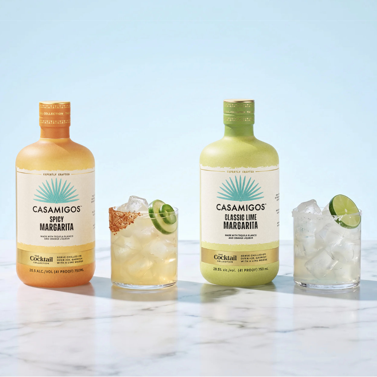 Ready-to-Serve Casamigos Crafted Cocktails in Spicy Margarita and Classic Lime Margarita flavors, served on the rocks with chili-lime seasoning, lime and jalapeño garnishes, and a salted rim on white marble.