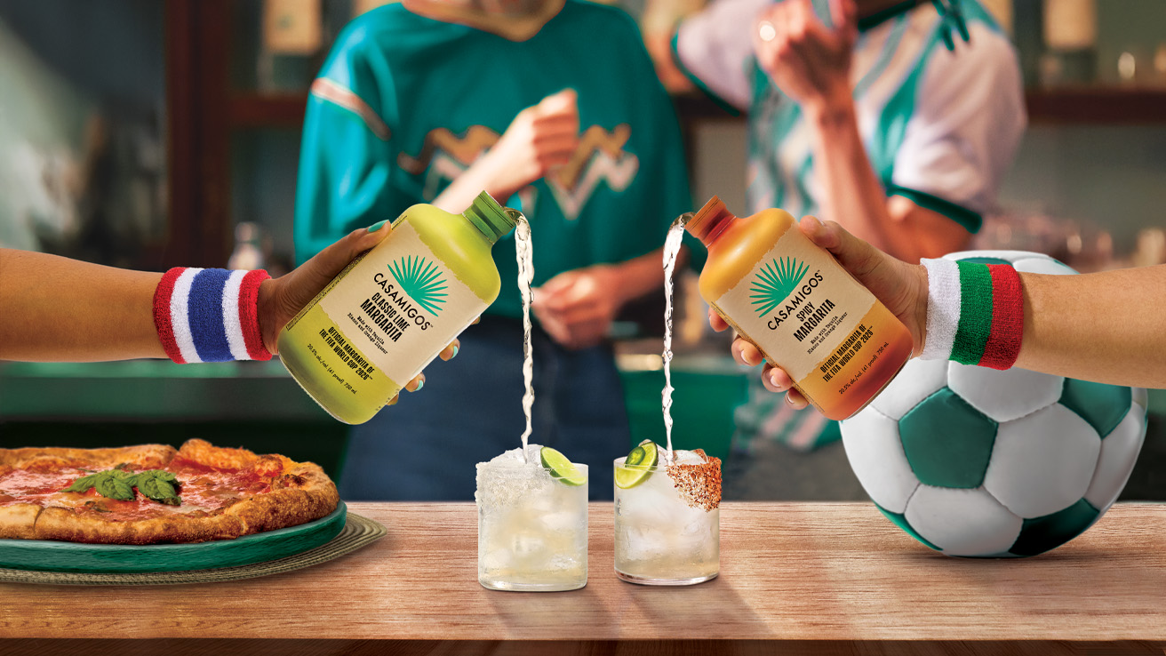 Casamigos Tequila Crafted Cocktails Classic Lime and Spicy Margarita bottles being poured into rocks glasses with ice.