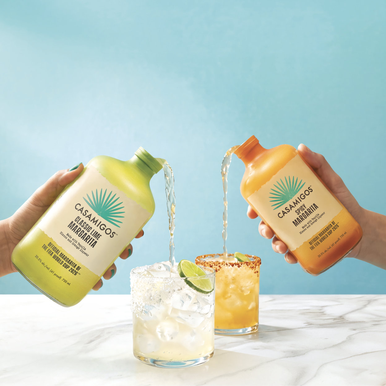 Two bottles of Casamigos Crafted Cocktails, Spicy Margarita and Classic Lime Margarita, laying in a field of green grass.